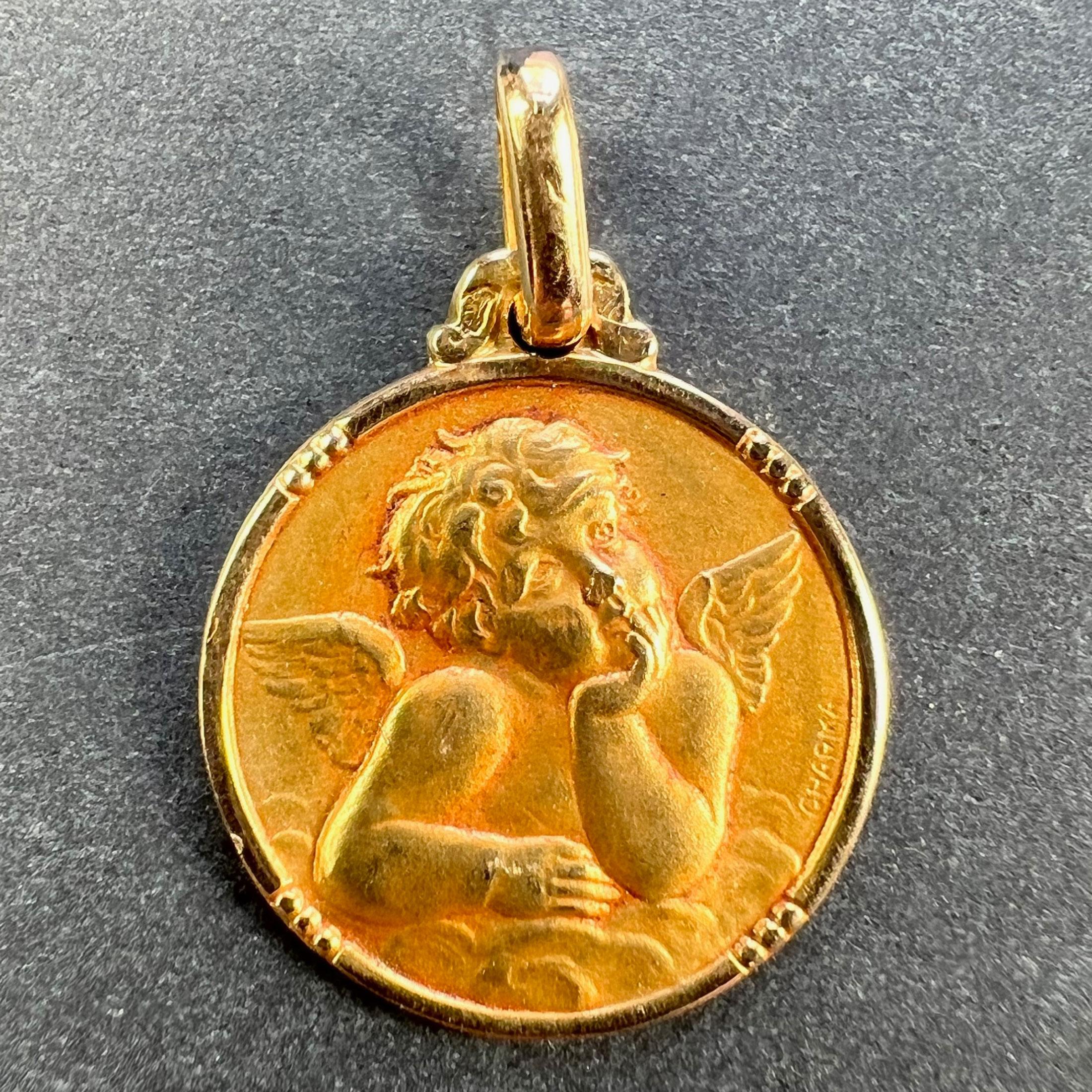 A French 18 karat (18K) yellow gold charm pendant designed as a round medal depicting Raphael’s cherub. Signed Charma. Stamped with the eagle mark for 18 karat gold and French manufacture with an unknown maker's mark.

Dimensions: 1.7 x 1.4 x 0.1 cm