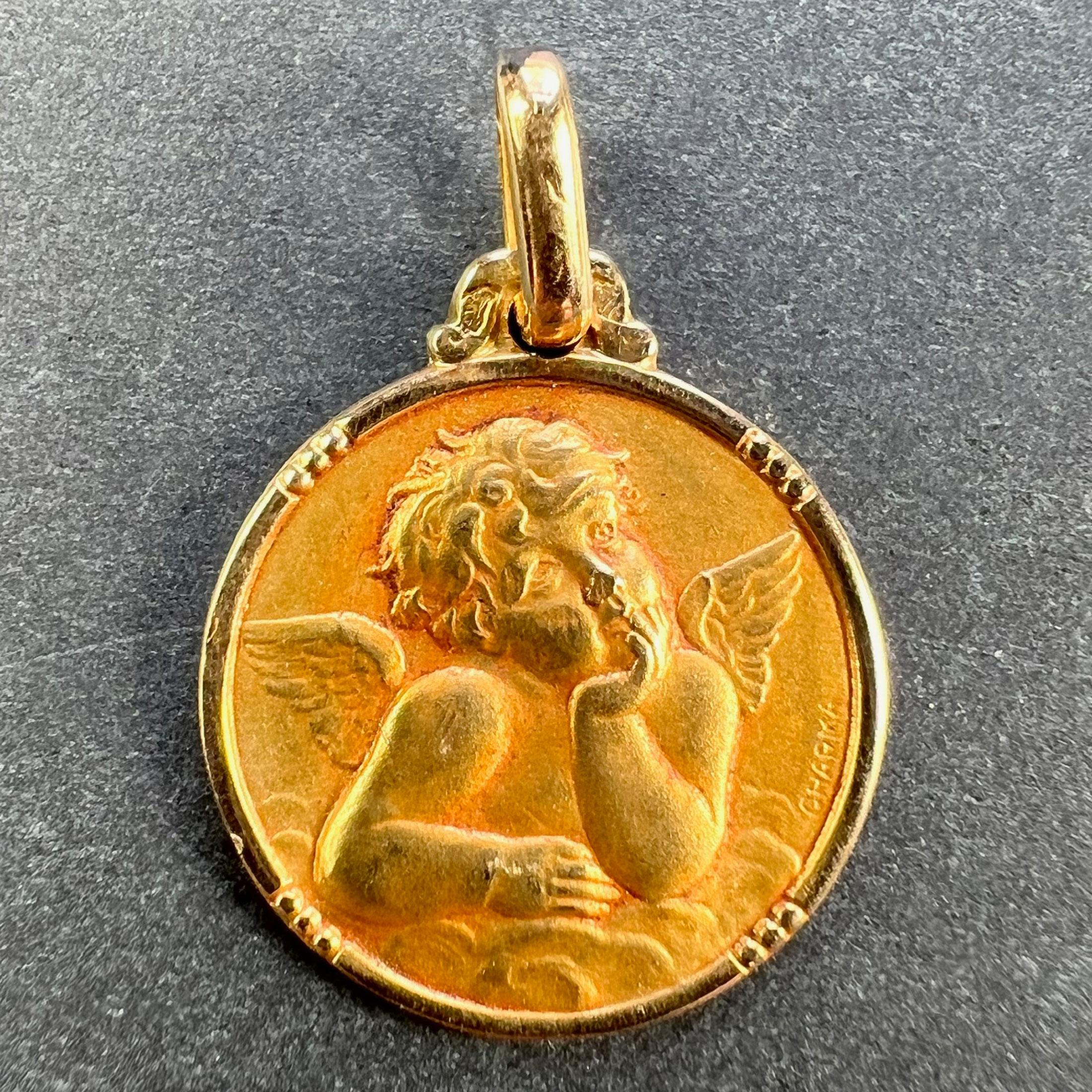 Ein französischer Anhänger aus 18 Karat (18K) Gelbgold in Form einer runden Medaille, die einen Cherub von Raphael darstellt. Gezeichnet Charma. Gestempelt mit der Adlermarke für 18 Karat Gold und französischer Fertigung mit unbekannter