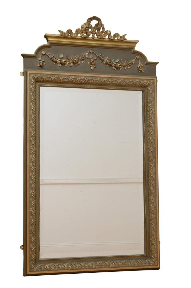 P0234 attraente specchio da parete francese, con vetro originale a bordo smussato in una cornice dorata modanata e intagliata a fiori con volute floreali su una tavola verde oliva e fiocco dorato sulla parte superiore. Questo specchio d'epoca