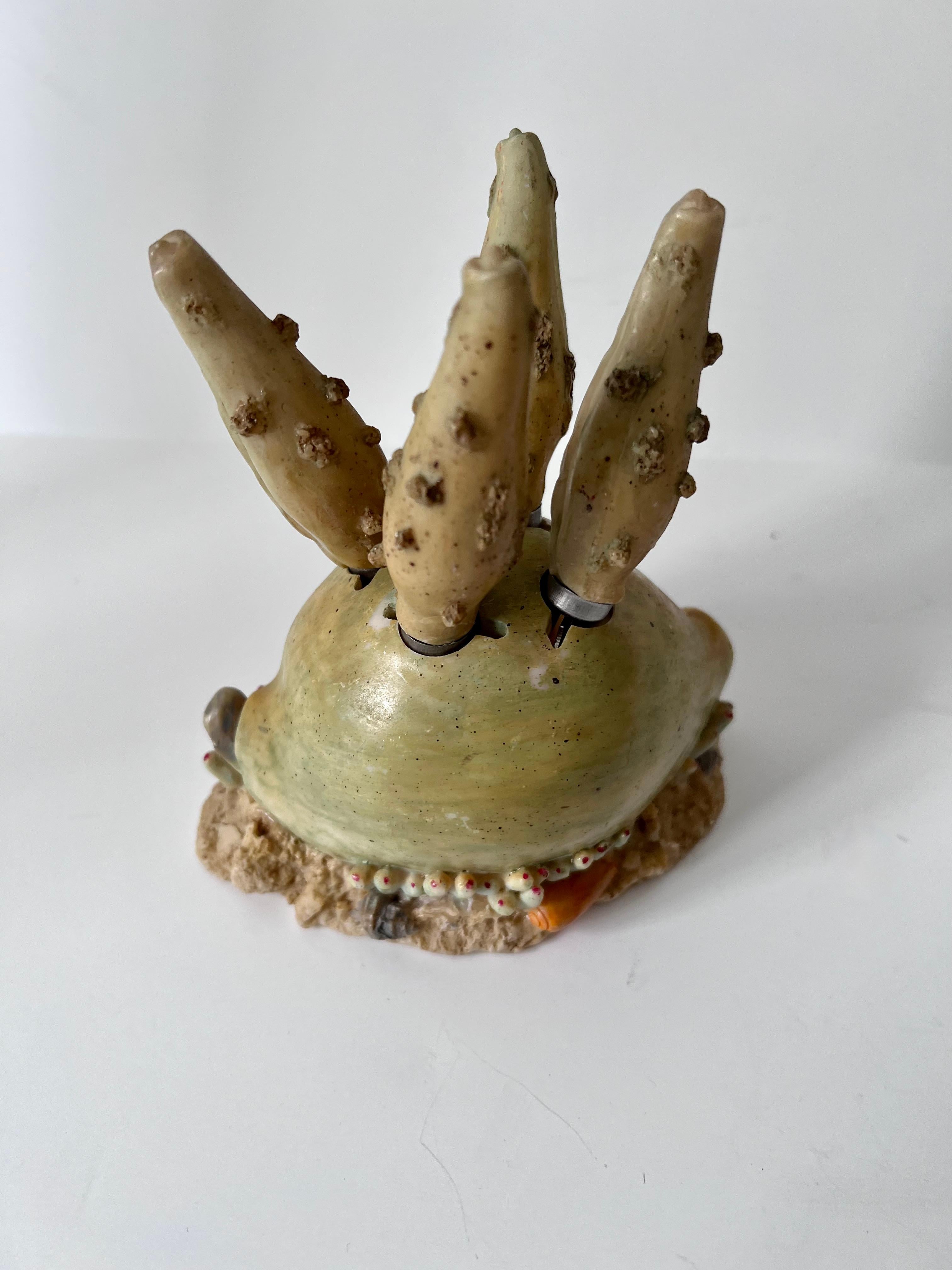 Recently acquired from Paris...A unique set of four cheese spreaders in a holder of a resin shell.  The four knives have a grotto look with the grotto holder.  A compliment to any cocktail table, bar or decorative piece in the kitchen.  