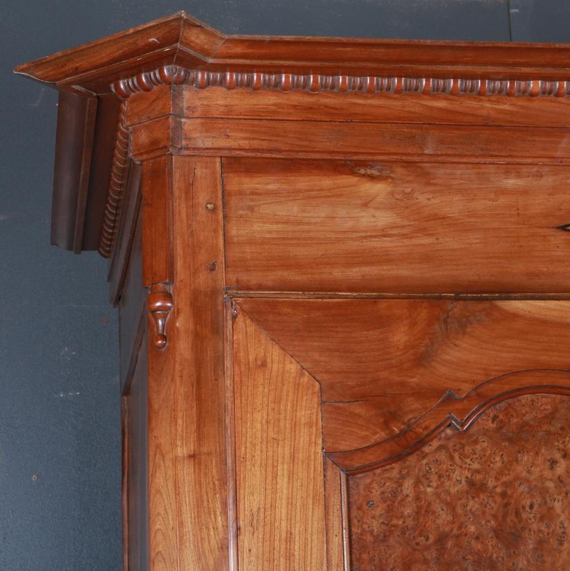 Early 19th century French cherry bonnetiere with burr walnut panels. This has got a removable cornice and full adjustable shelves. 1820

The internal depth is 22