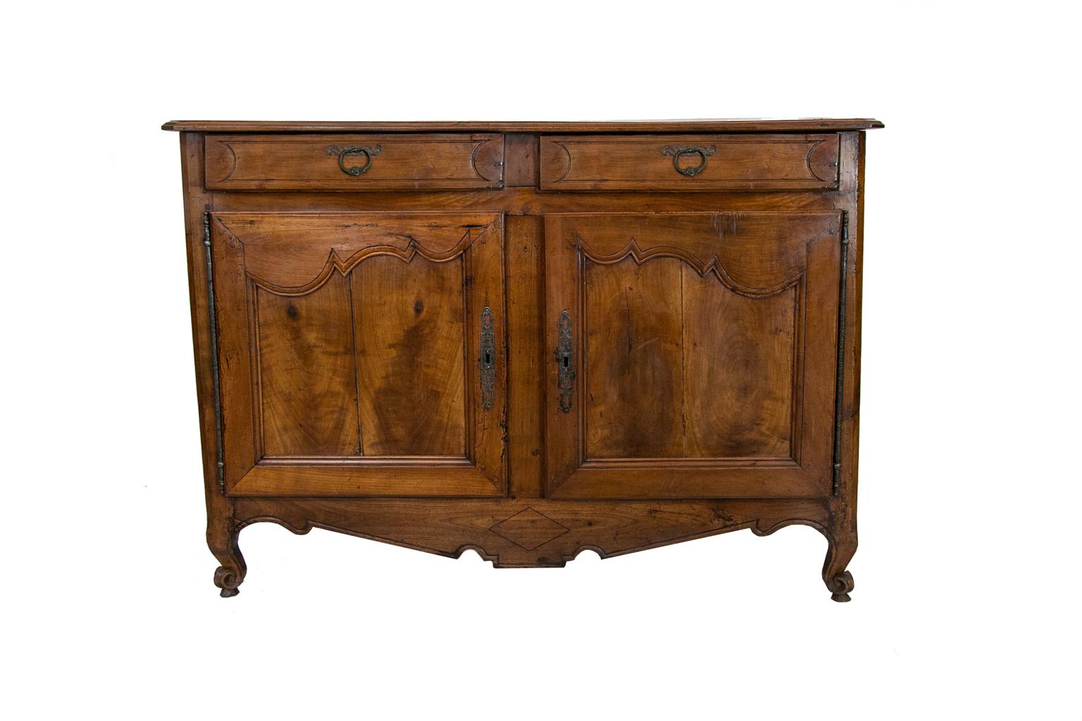 This French cherry buffet has carved incised lines in the drawer fronts. The doors have recessed panels framed with carved molding. The edges of the doors have carved chamfers. There is double peg construction throughout. The top left drawer has its