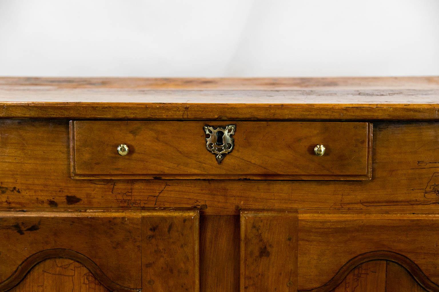 This buffet has double peg construction. The sides have recessed panels. The top has significant spotting in the patina. The hardware is later. There is one fixed shelf.