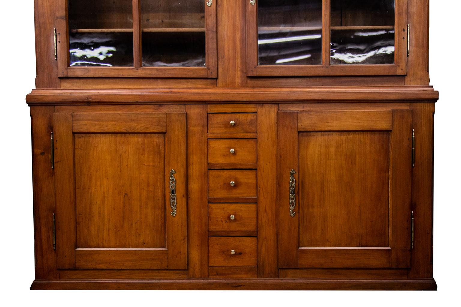 This cherry cabinet has the original blown glass panes and double peg construction. Each side of the top half has three adjustable shelves. The upper and lower doors have separate original locks that all have the original working keys. The lower