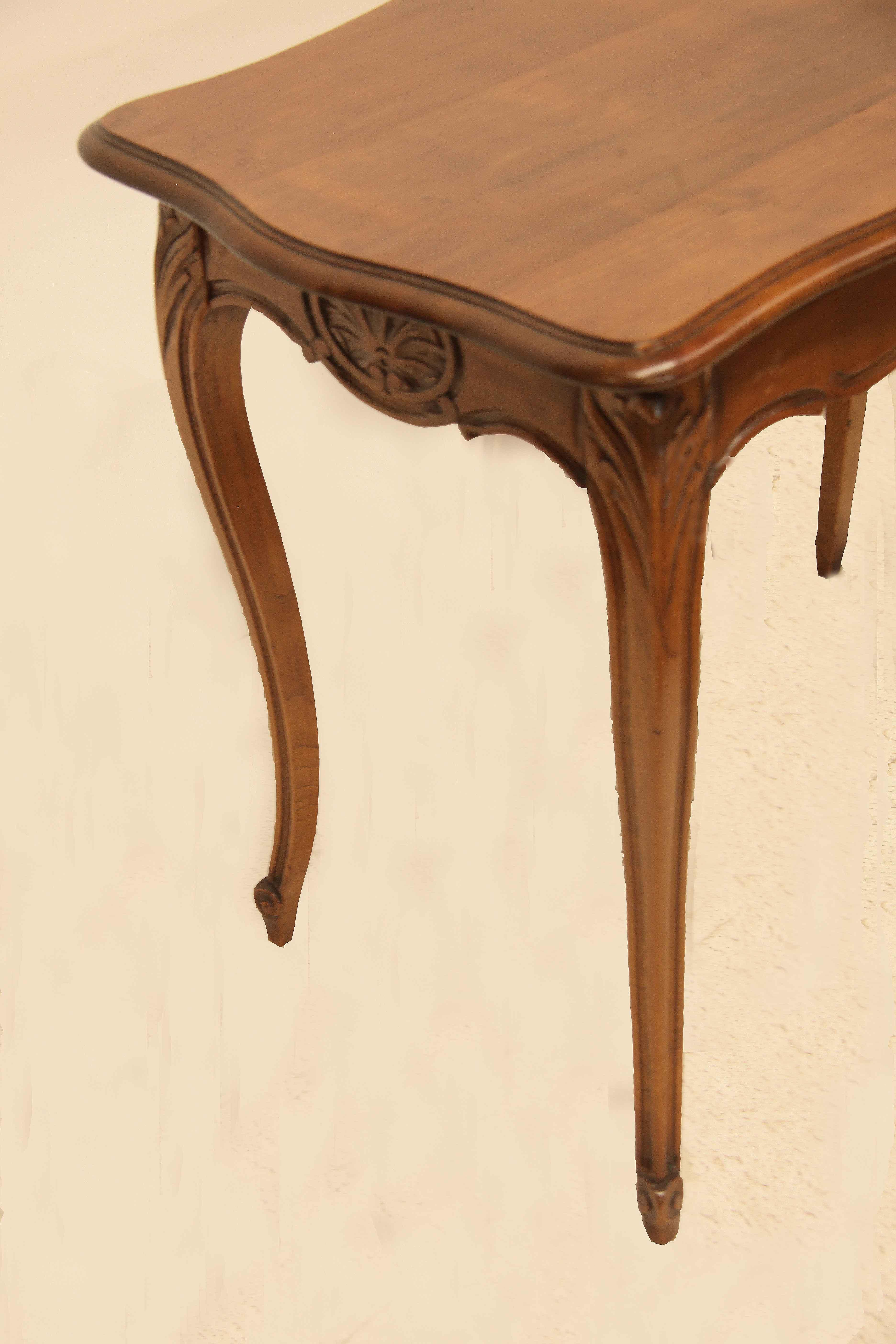 French cherry center table, the serpentine shape front and sides each have a central carved medallion, the top has a beautiful color and patina with continuous molded edge around the perimeter; cabriole legs with acanthus carved knees and scrolled
