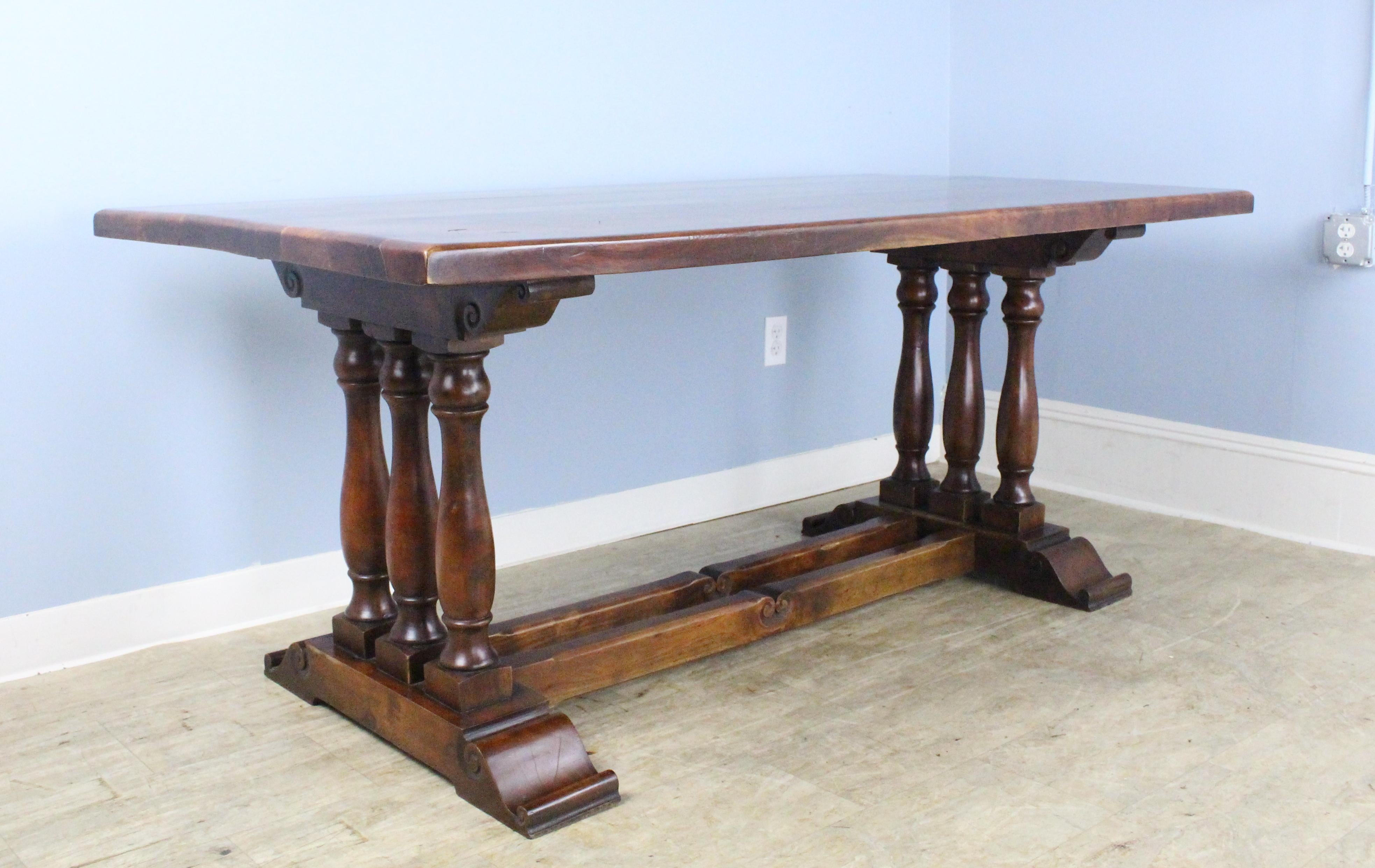 A solid cherry farm table with a dramatic, whimsical base and a thick top. The cherry is in very good condition as are the artfully carved triple column legs and double trestle. A work of art that you can eat on!