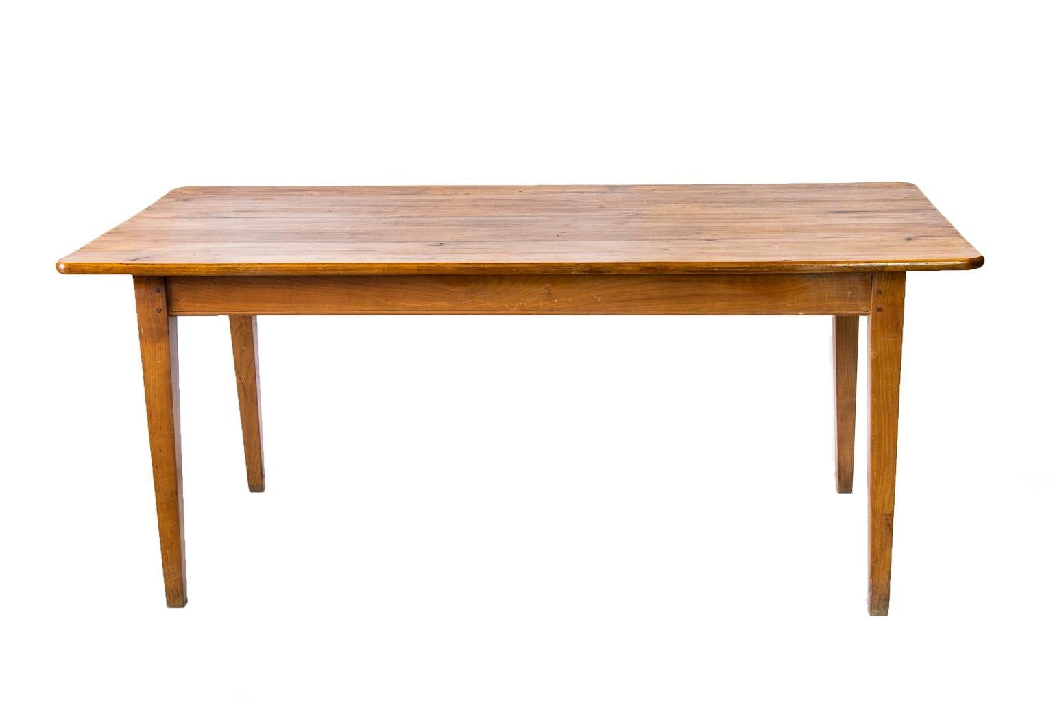 French cherry farm table has double peg construction and bullnose molding at the base of the apron.