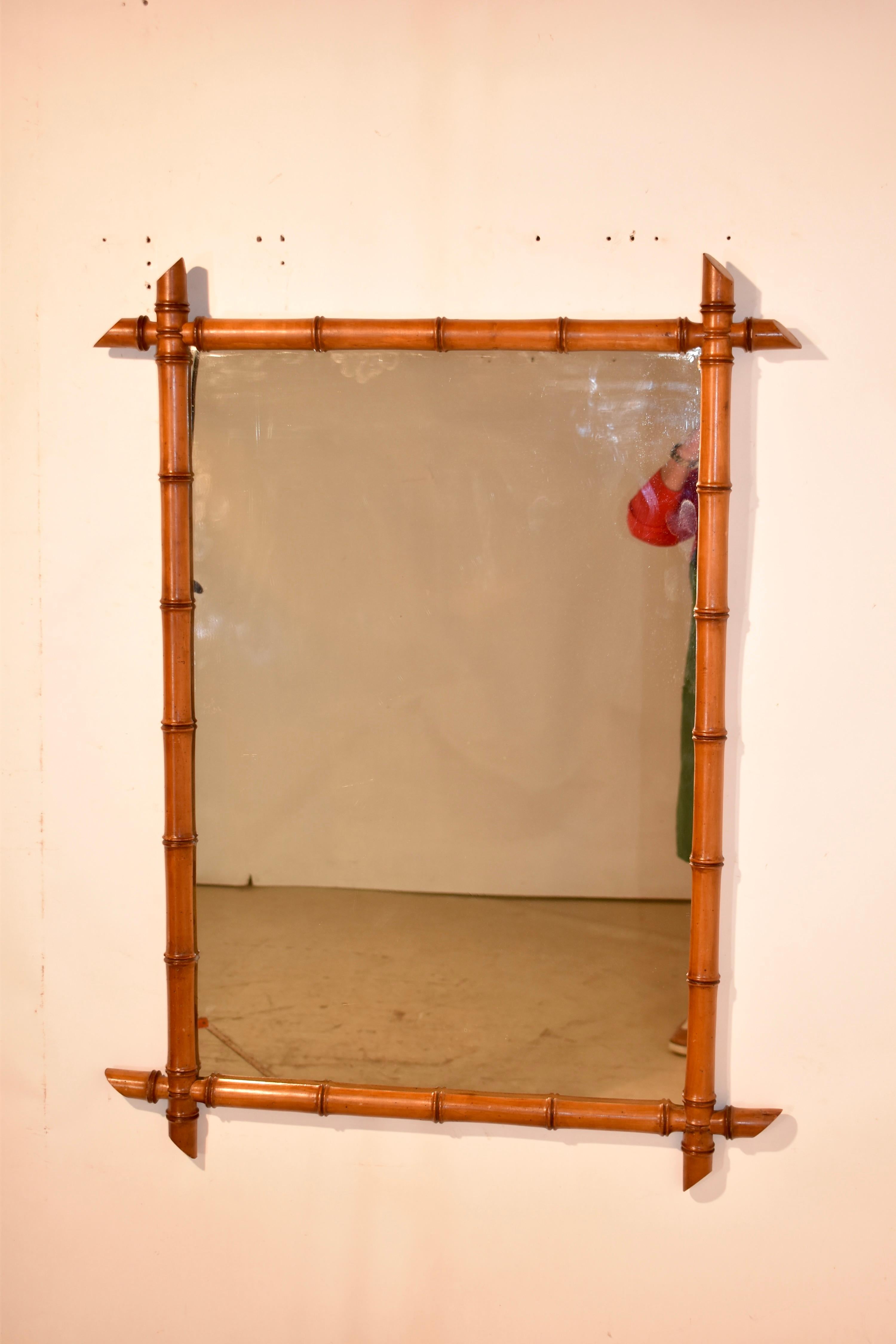 Specchio da parete in finto bambù francese del 1920 circa, realizzato in ciliegio.  La cornice è meravigliosamente tornita a mano in modo da avere l'aspetto del bambù e circonda un semplice specchio.  Sono splendidi e aggiungono un tocco di eleganza
