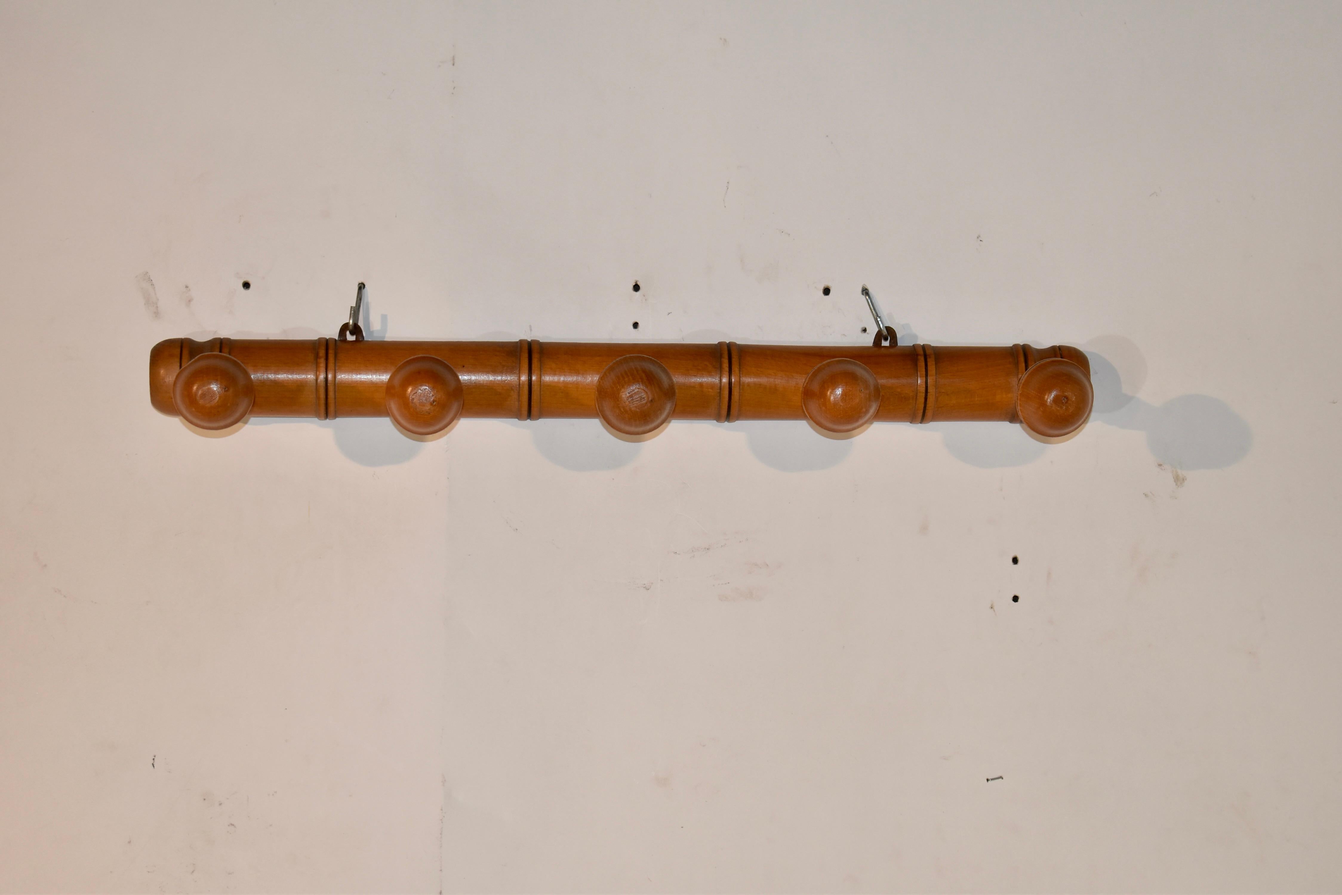 Circa 1920 five peg hat or coat rack from France, made from cherry. The back of the rack is designed with raised molding, to give a look of bamboo, and it has five hand turned lollipop pegs for hanging hats or coats. These are also great in a