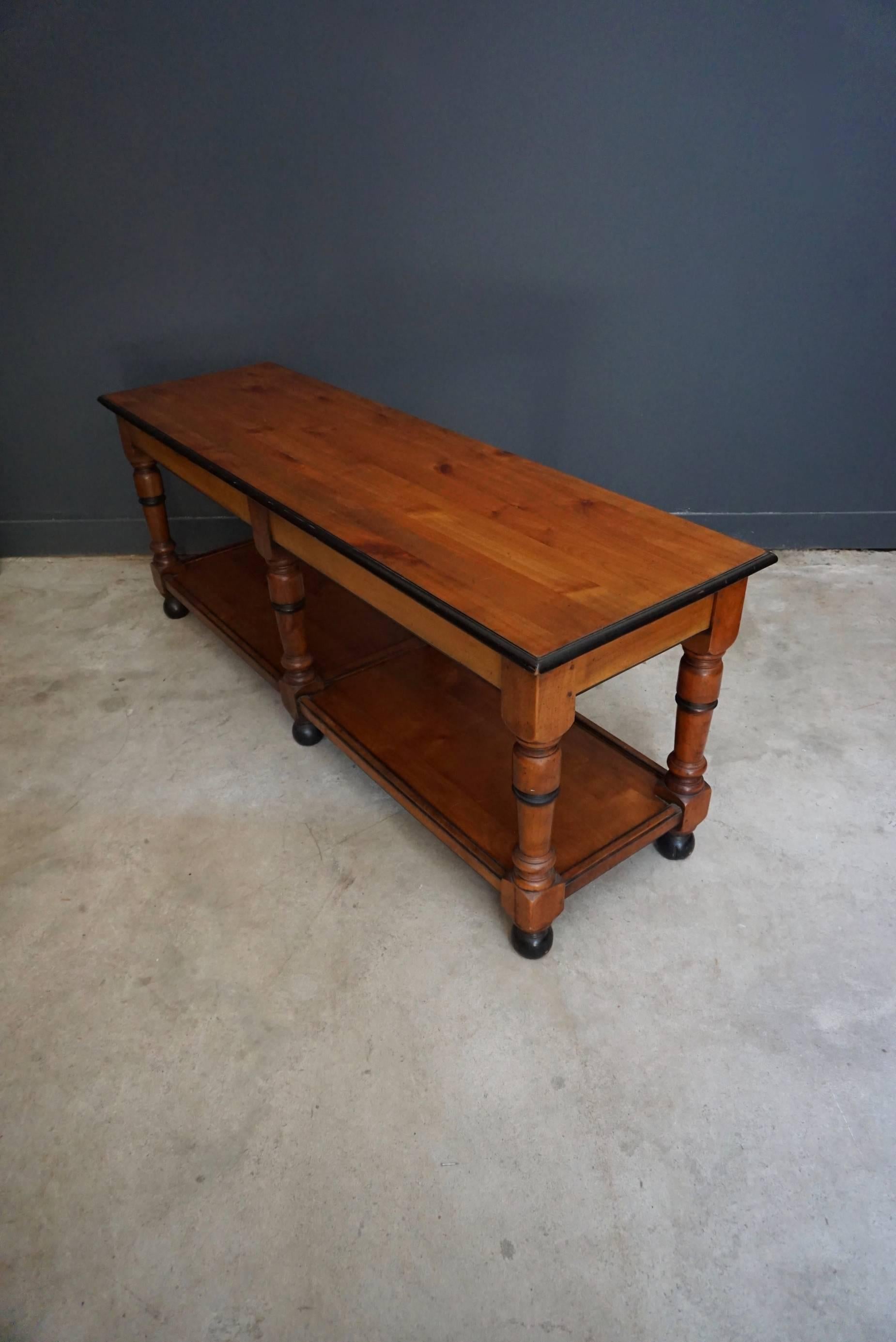 This French console table was designed and made around the late 19th century from solid cherry wood. It remains in a very good condition. It can be used as a display table in a shop or as a side table.