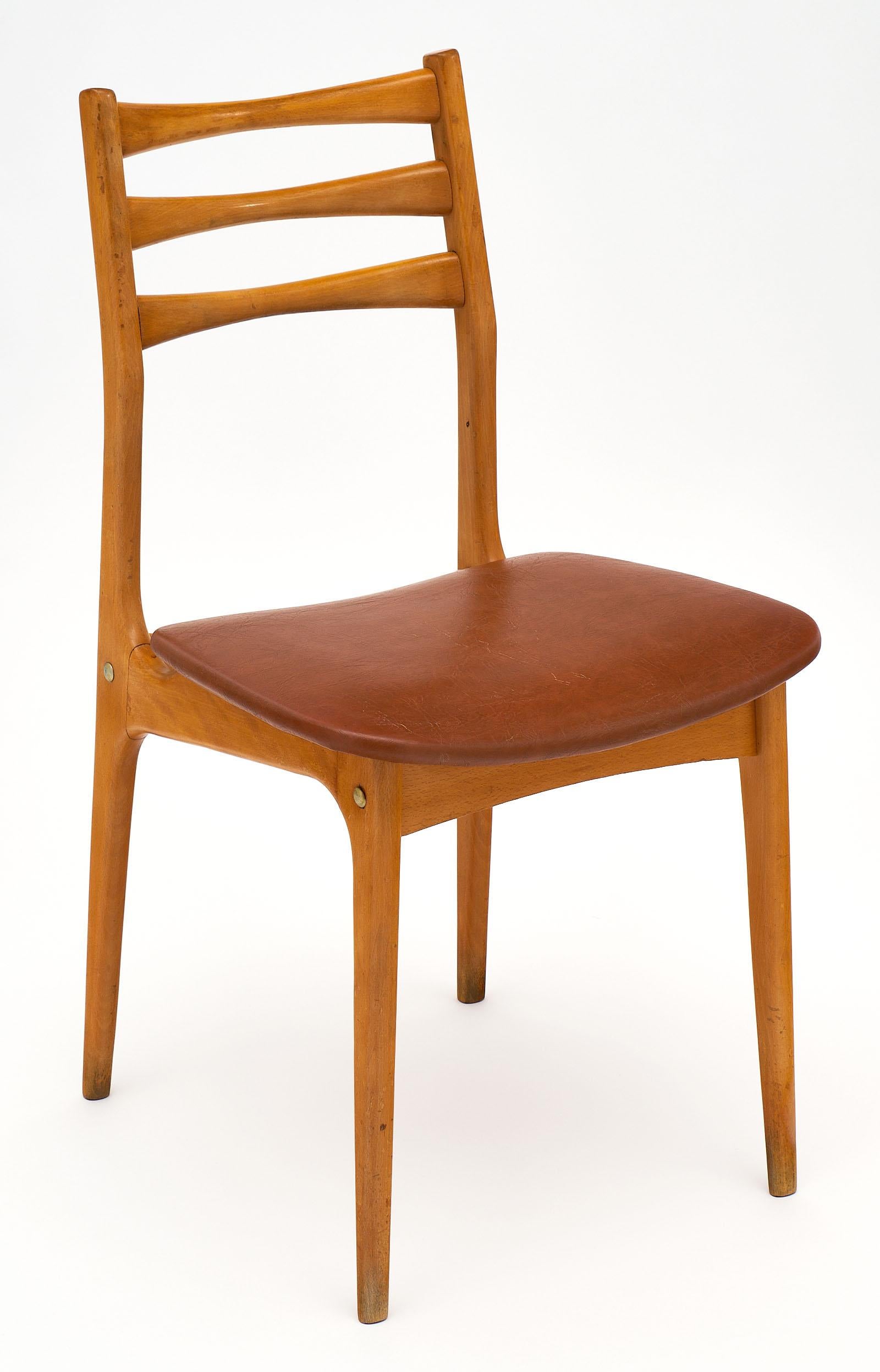A set of six midcentury French cherrywood chairs finely crafted of with stylish, strong, and comfortable frames. The original vinyl seats have been professionally repaired, please see the photo for details.