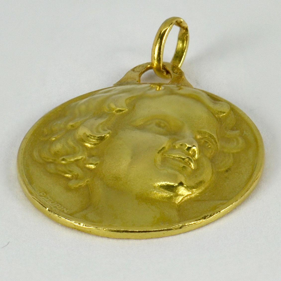 An 18 karat (18K) yellow gold charm pendant designed as a medal depicting a cherub’s head. Signed P. Turin, stamped with the eagle’s head for French manufacture and 18 karat gold.

Dimensions: 2 x 1.8 x 0.25 cm (not including jump ring)
Weight: 4.54