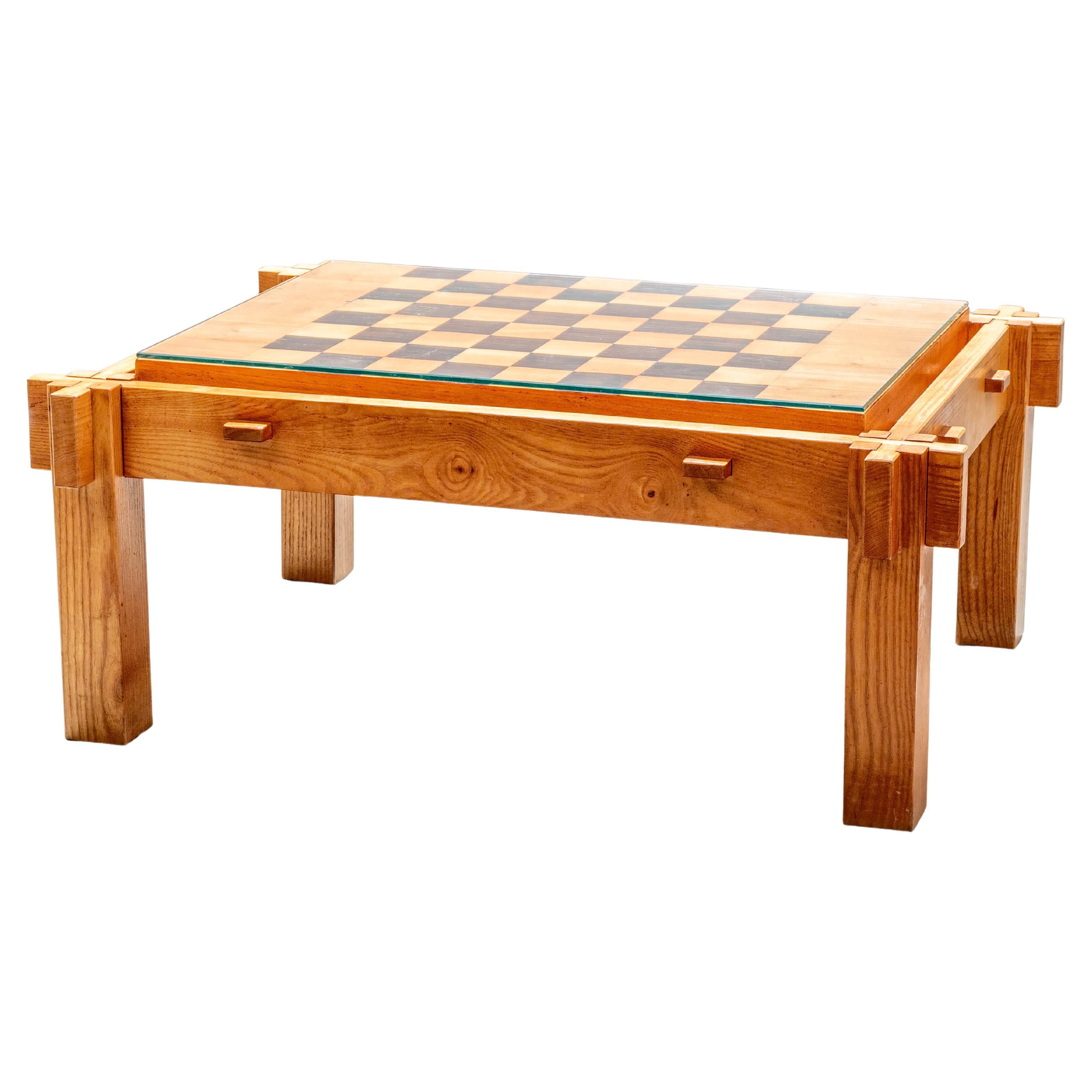 A low chess table in the style of Pierre Chapo with interesting corner corner construction. It's also a very heavy and stable (not unimportant) chess table in solid blonde elm. As always, chessboards give a special touch to the room mainly because