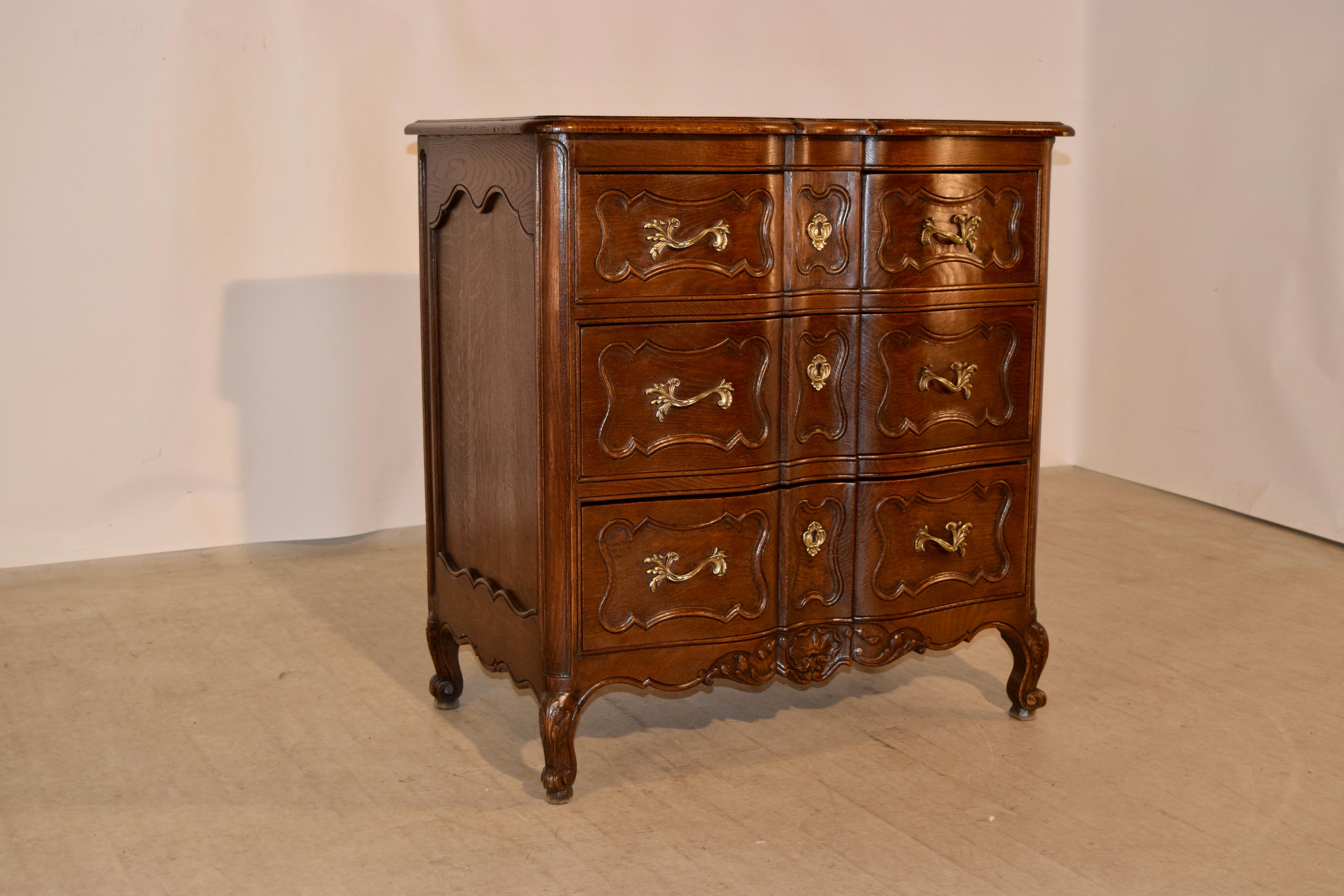 French chest of drawers made from oak, circa 1940. The top is shaped and has a bevelled and banded edge over three serpentine front drawers which have shaped raised panels and lovely hand cast pulls and escutcheons. The sides have shaped raised