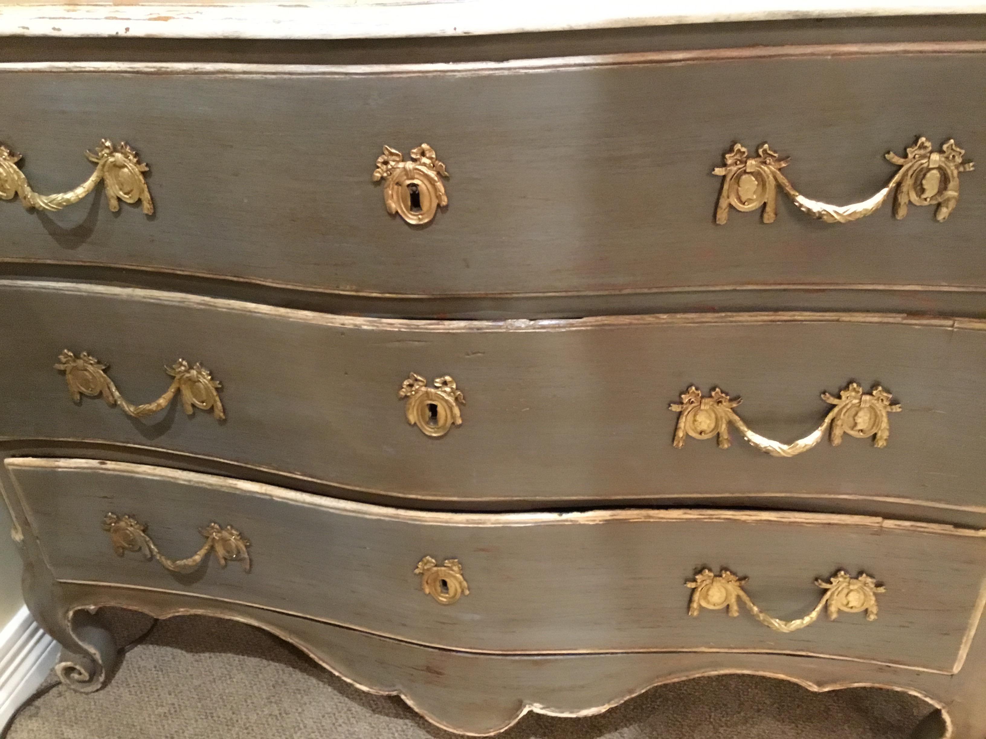 Handsome and beautiful chest that is polychromed in French gray-green hue. Faux
Painted in artful distressed manner. Louis XV style, the three drawers are raised on
Cabriole curled feet. Highlights in pale cream along the top edge and the