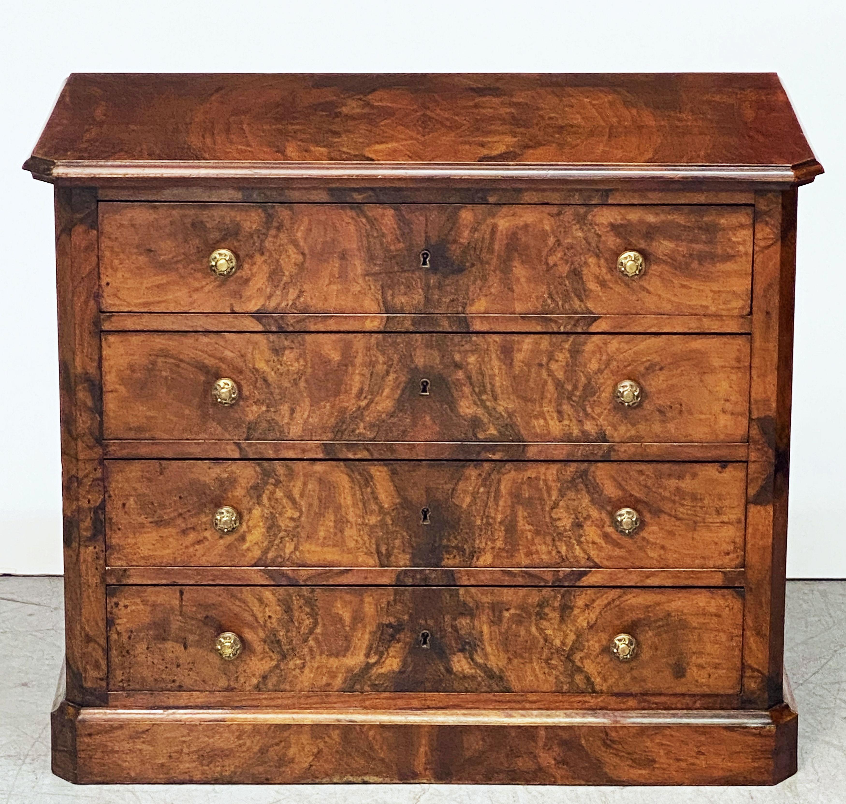 A fine French commode or chest of drawers featuring lovely flame walnut veneers on the front, sides and top.
With four drawers, each drawer with two decorative brass knob pulls, and resting on a raised plinth base.
    