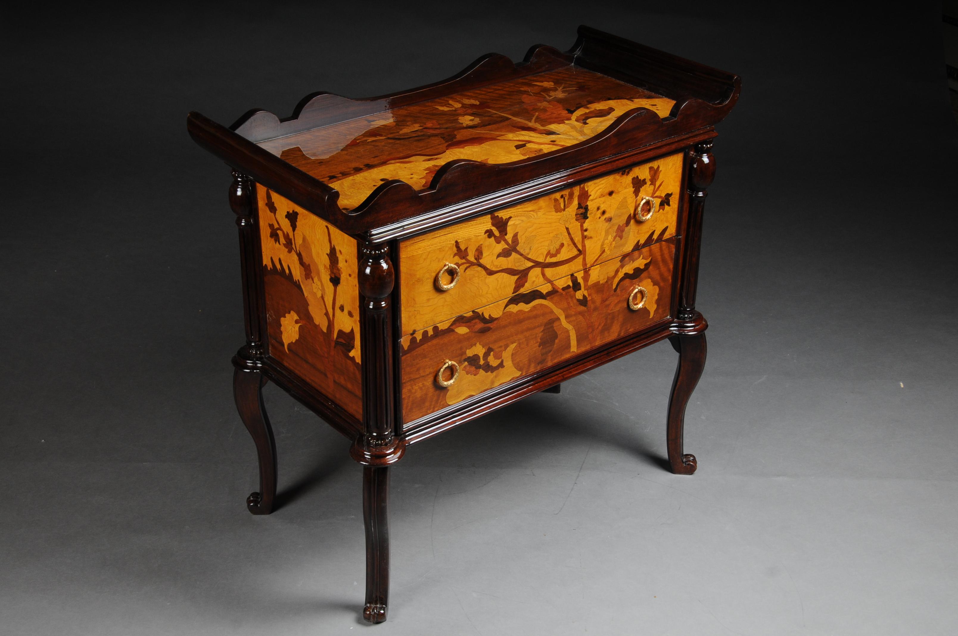 French chest of drawers with shelf Tray Art Neveau.
All-round hand-inlaid inlays with Art Nouveau motifs. Landscaped to Gallé
Solid wood with different inlaid precious veneers. Carcass case on slanted, curly legs.

(D-Gm-220).