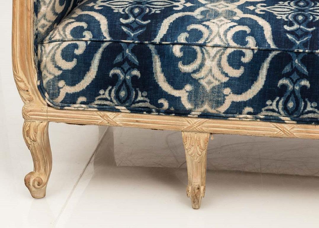 One-of-a-kind Chesterfield sofa made in France, updated in blue ikat pattern linen fabric by Andrew Martin. Deep, high-back seat and traditional scrolled arms with generous seating for two. The bleached oak wood frame is hand carved with intricate