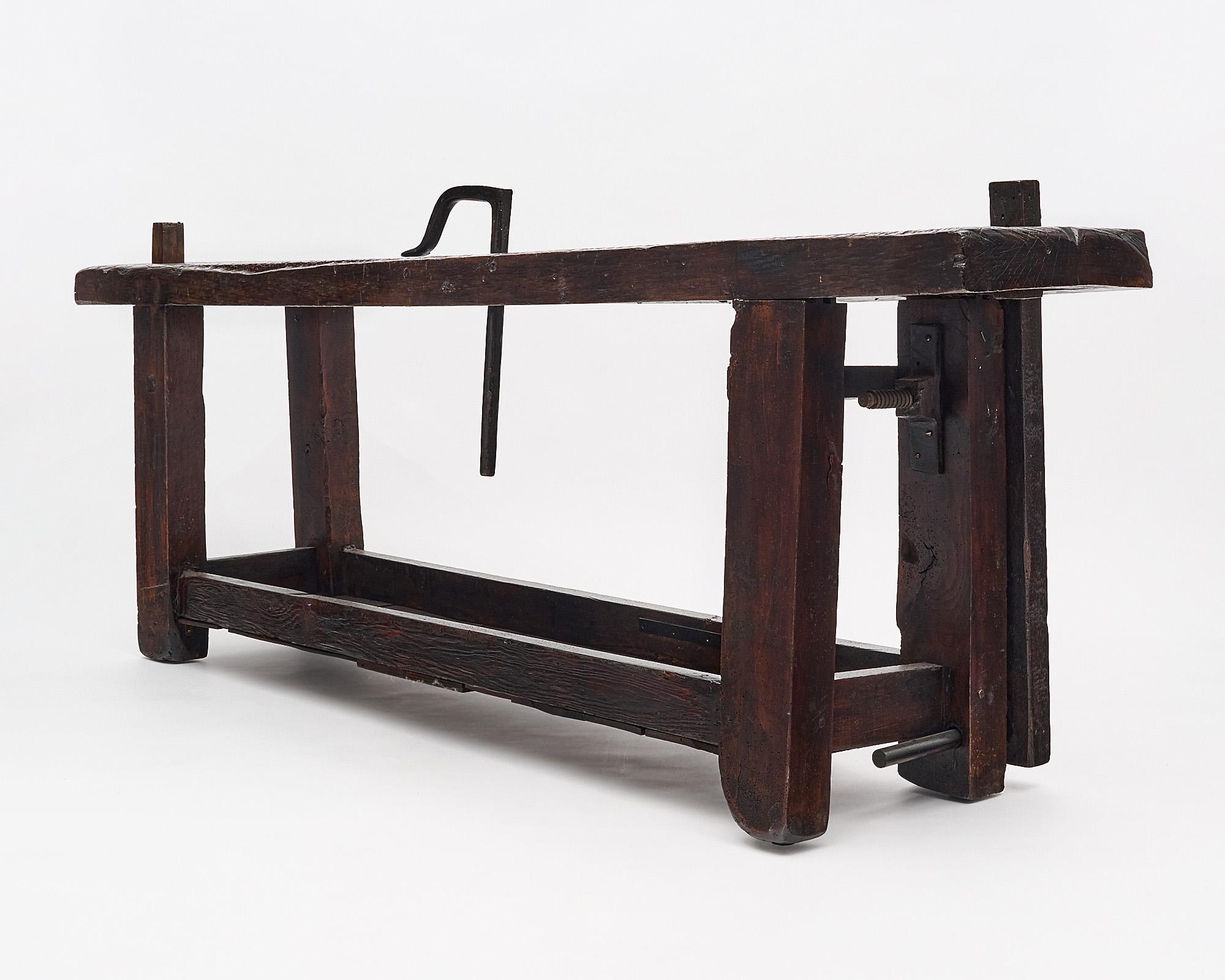 Workbench, French, made of stained and waxed chestnut. The piece features a single top plank, a shelf, and the original vise. The depth listed includes the vise, the depth of the top alone is 17”. The height listed is to the top of the table, it is