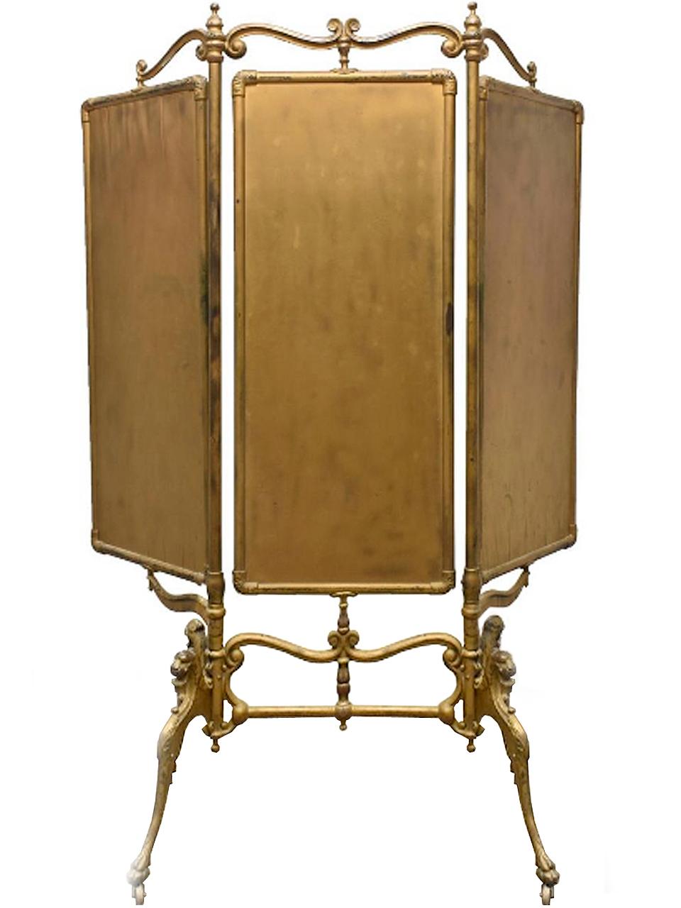 This French triple fold iron dressing mirror is finished in worn gilt paint and beveled mirror plates, rising on the griffin stand with paw feet on casters. I always thought that this was the most beautiful and desirable mirrors. The aged patina is
