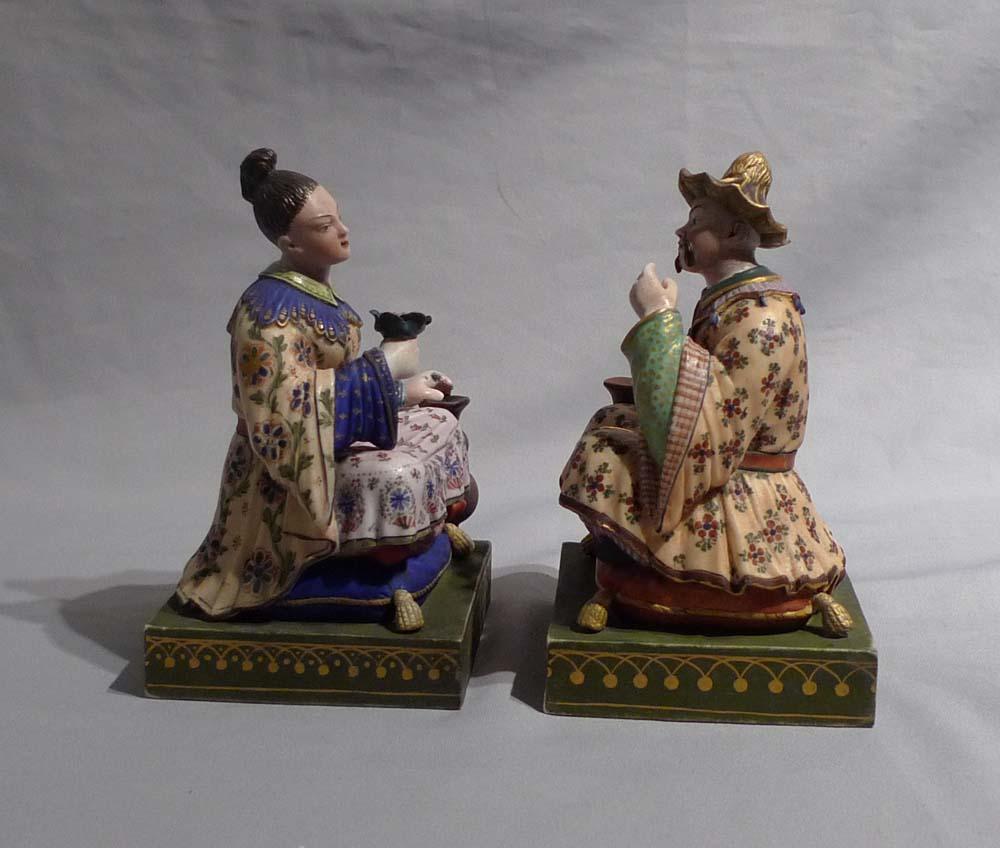 Pair of French porcelain Chinnoiserie or Chinese figures. Beautifully executed and painted in polychrome. Both figures are seated on cushions. Almost certainly French from the beginning of the 19th century but with no discernable marks.