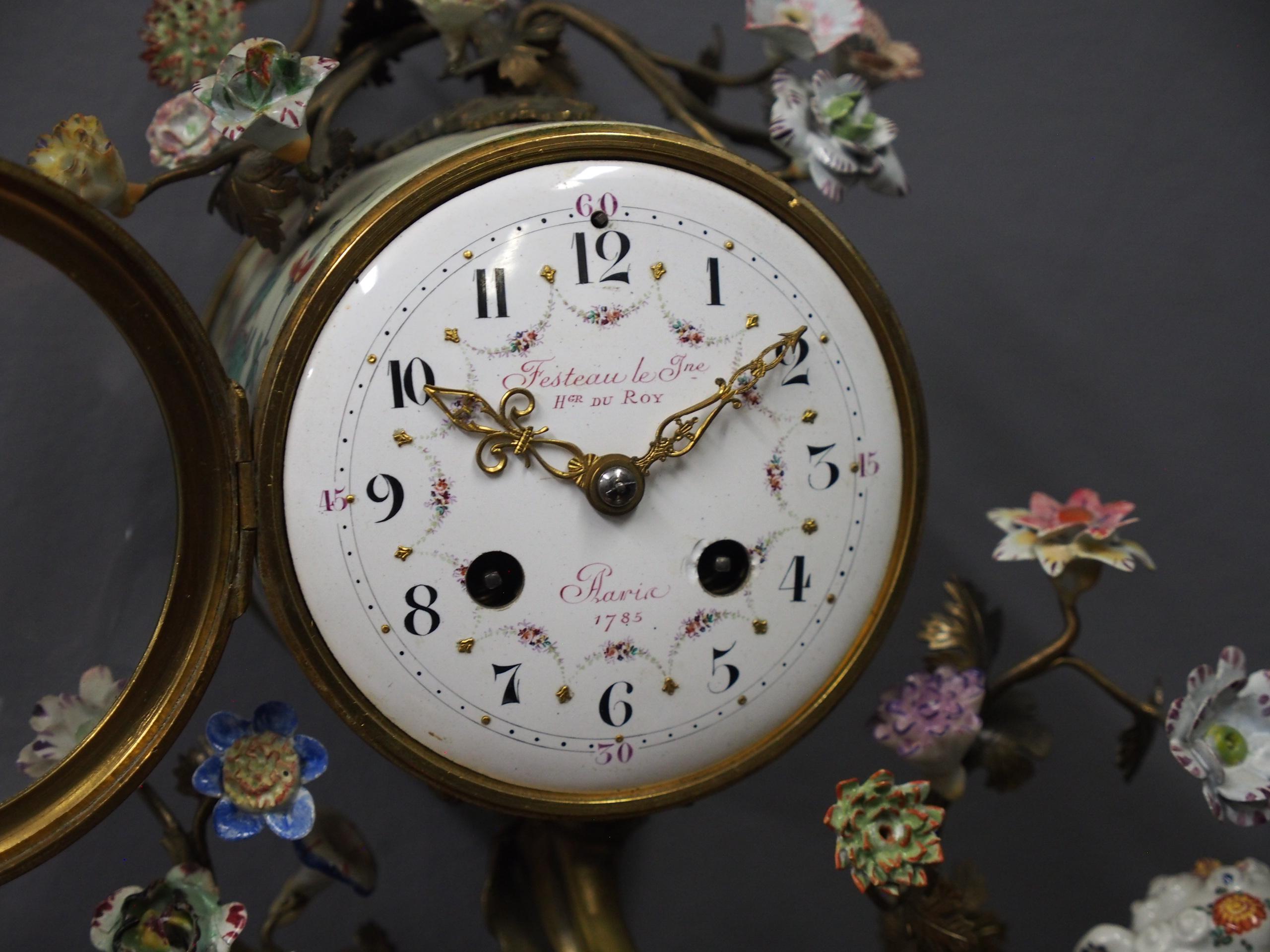French gilded brass and porcelain mantel clock. With Chinese motifs, painted Arabic numerals and a makers or retailers name to the face of ‘Festeau le Jne, HGR DU ROY… Paris 1785’. To the back is a pendulum with a sunburst, cherub face and it has