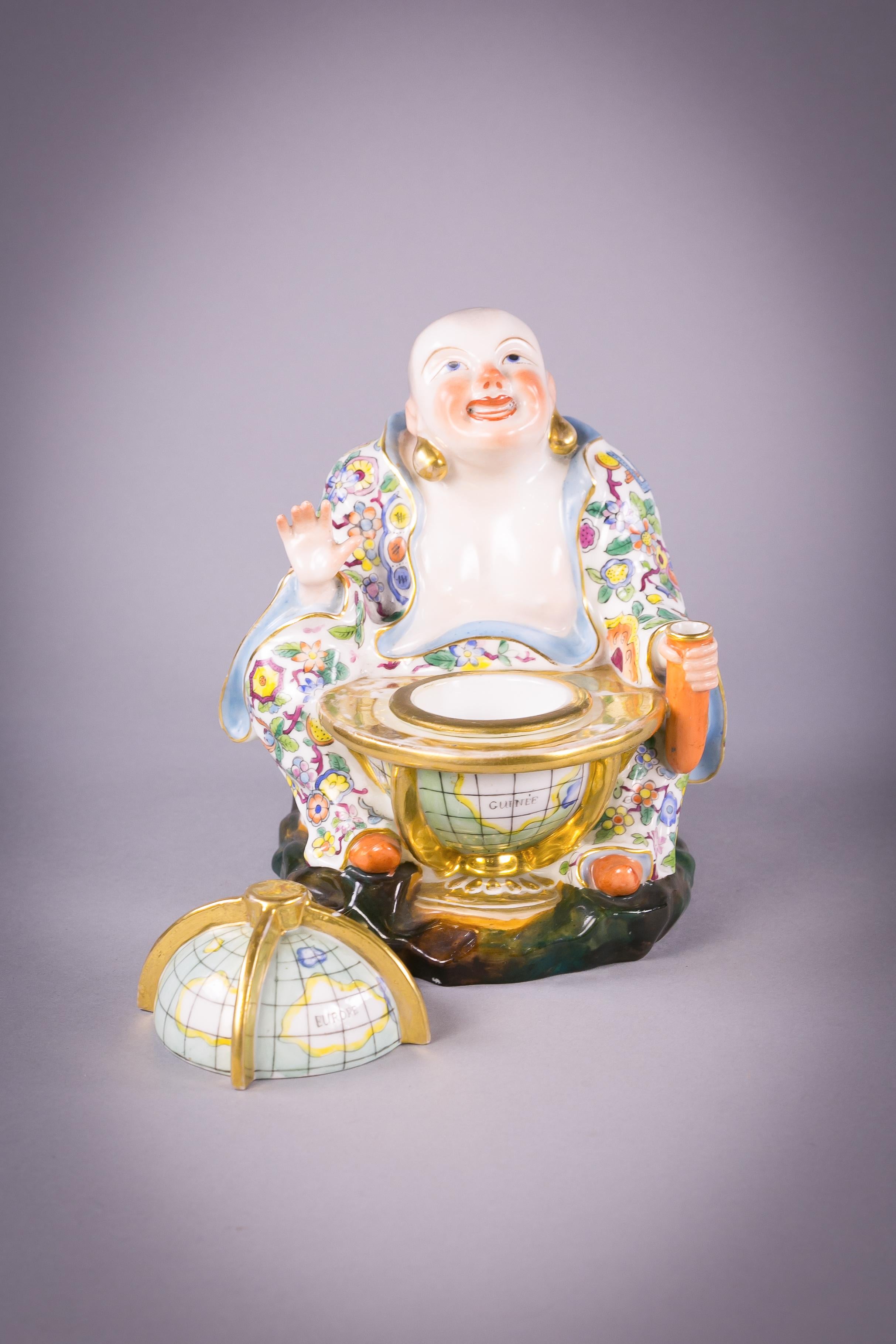 Mit abnehmbarem Globusdeckel, der ein abnehmbares Tintenfass offenbart. Der chinesische Buddha hält in seiner linken Hand einen Federkielhalter.