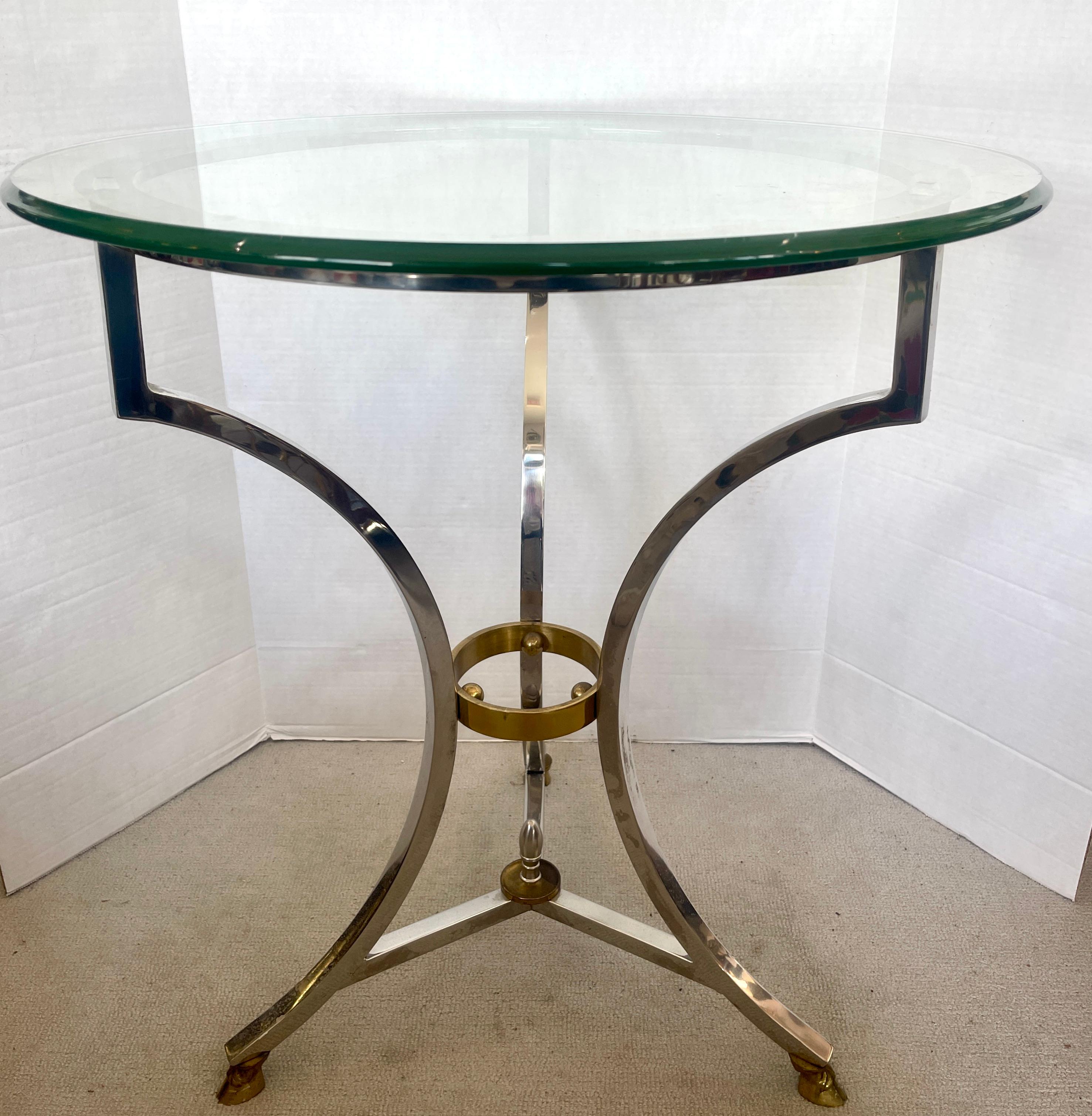 This is a fine example of a French chrome and Brass Gueridon with a Glass Top.
Thus  guidon is made of Chrome & Brass with a round  Glass Top, 
This charming table is attributed  to Mason Jansen, 1950-1960
The main base is Polished Chrome With Brass