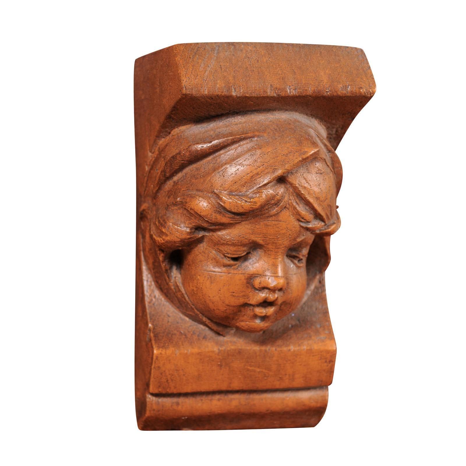 A French terracotta wall bracket from the 20th century depicting an angel face. This charming 20th-century French terracotta wall bracket is a delightful piece of artistry that effortlessly captures the innocence and beauty of an angelic face.