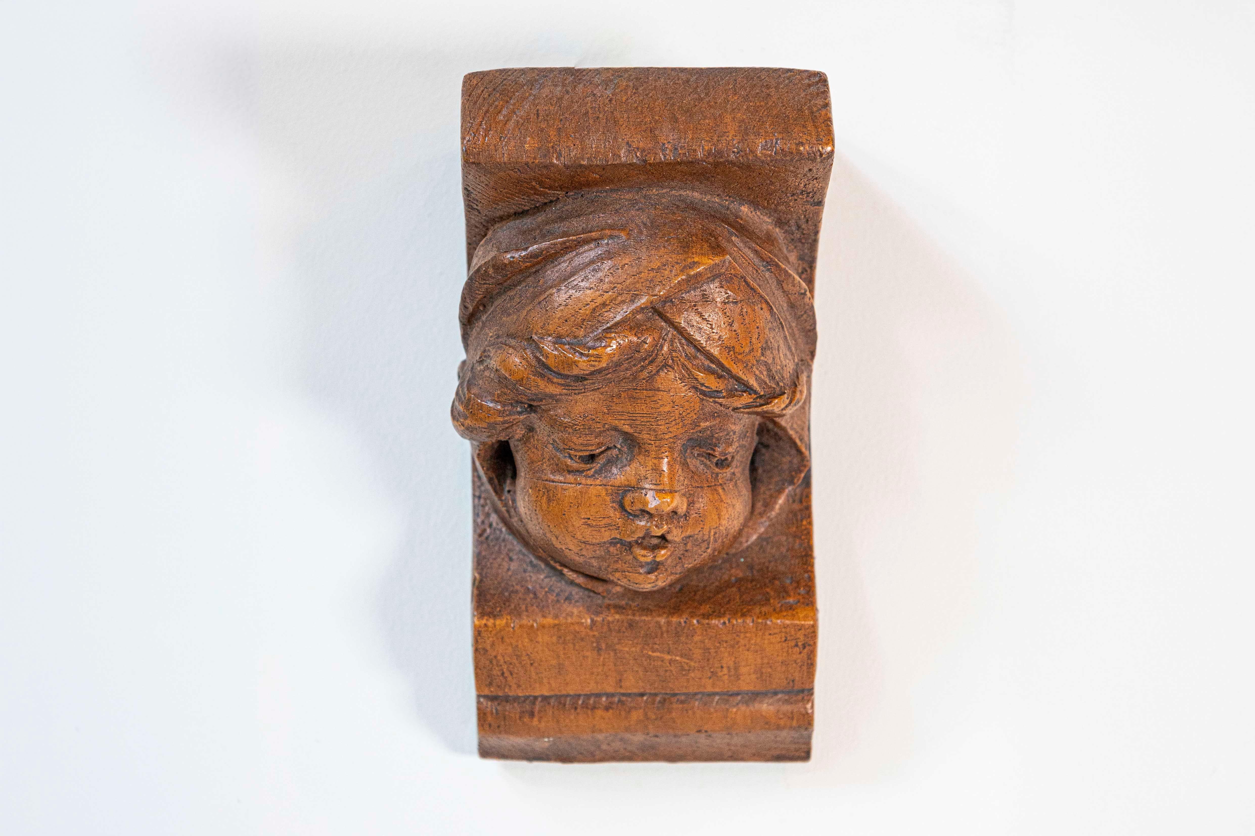 A French terracotta wall bracket from the 20th century depicting an angel face. This charming 20th-century French terracotta wall bracket is a delightful piece of artistry that effortlessly captures the innocence and beauty of an angelic face.
