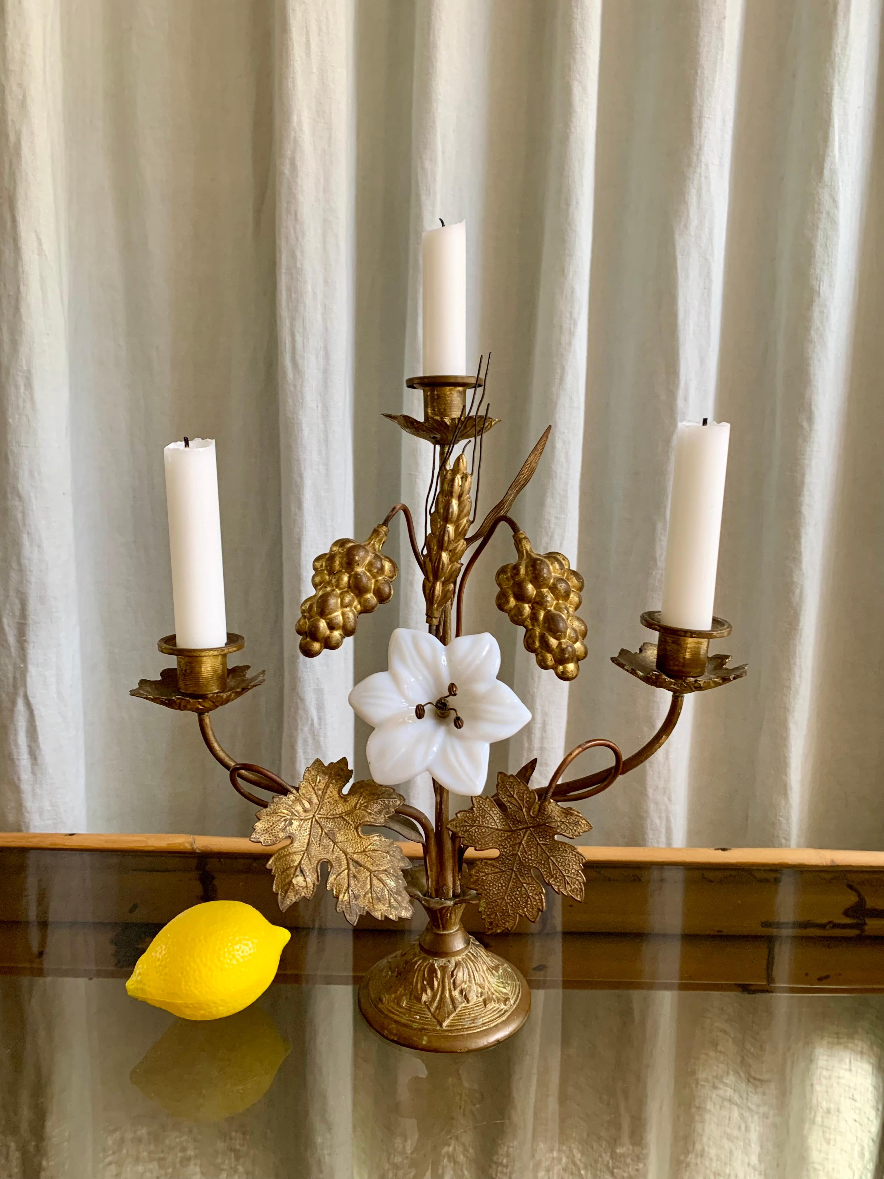 Antique French gilt brass church candelabra with wine leafs, bunches of grapes and an ear of grain. One centered opal glass lily and holders for three candles. The candelabra has beautiful patina.