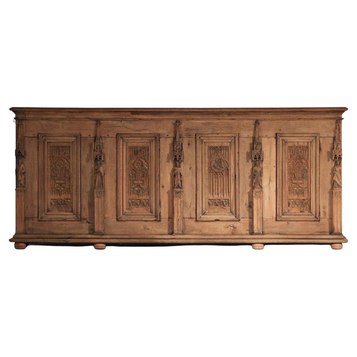 Gothic sideboard from the 1910s/1920s. Entirely hand-carved in solid wood, this work of art was certainly commissioned for a church. Superb detail in the figures and rosettes that adorn the entire buffet. The cabinet has been sandblasted in the