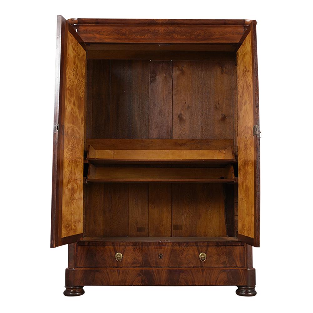 This French Late 18th-century Louis Philippe Two Doors Armoire has been completely restored, is made from flemish mahogany wood, and has its original finish. It features a beautiful molded top and two large carved doors with original lock and key in