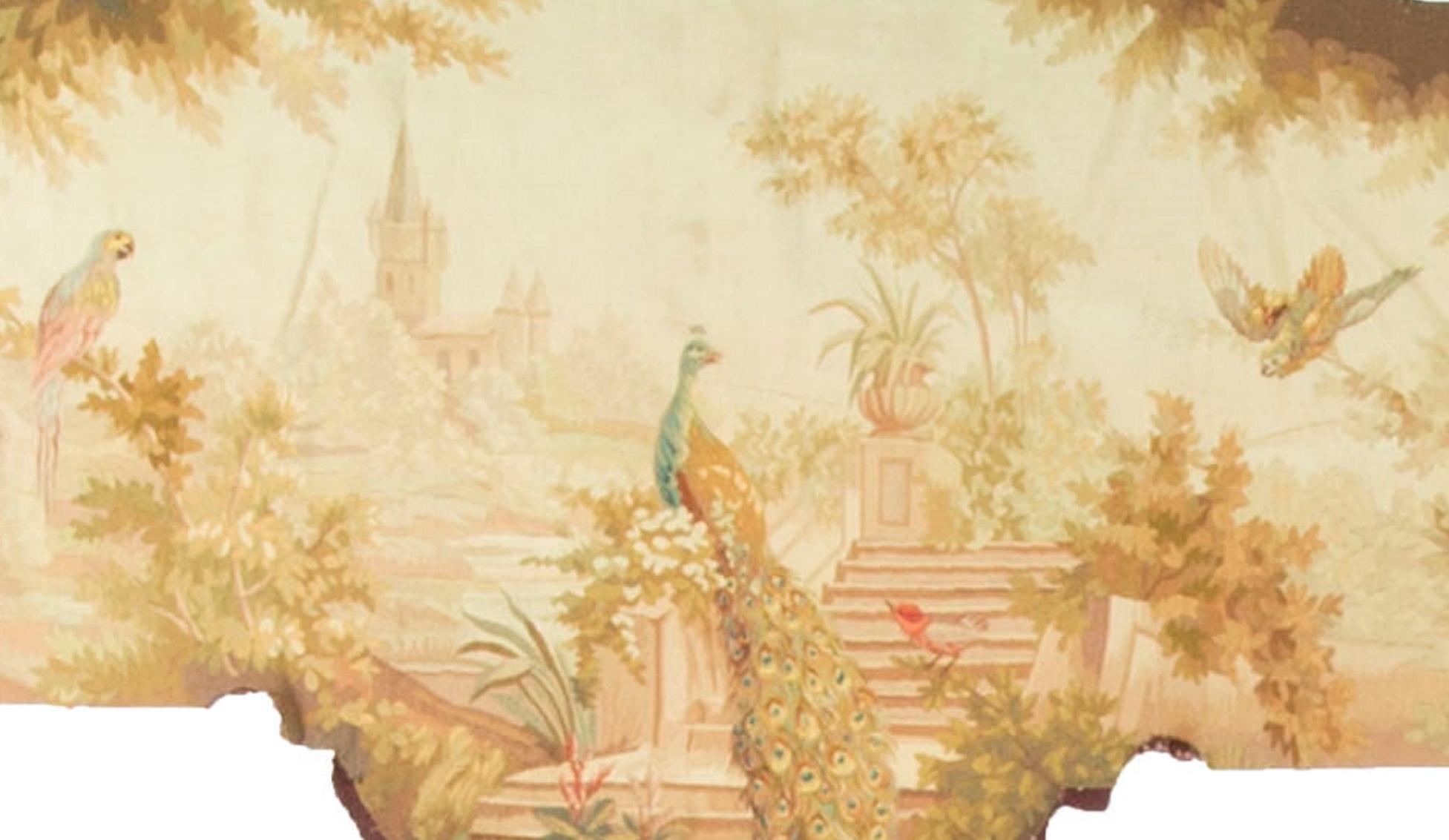 A wonderful French circa 1830 tapestry panel. The peacock sitting so proud, in the foreground, on steps leading to a country house. Other birds are either perched or flying in the country side so well depicted in this panel. One of a pair. 
 
