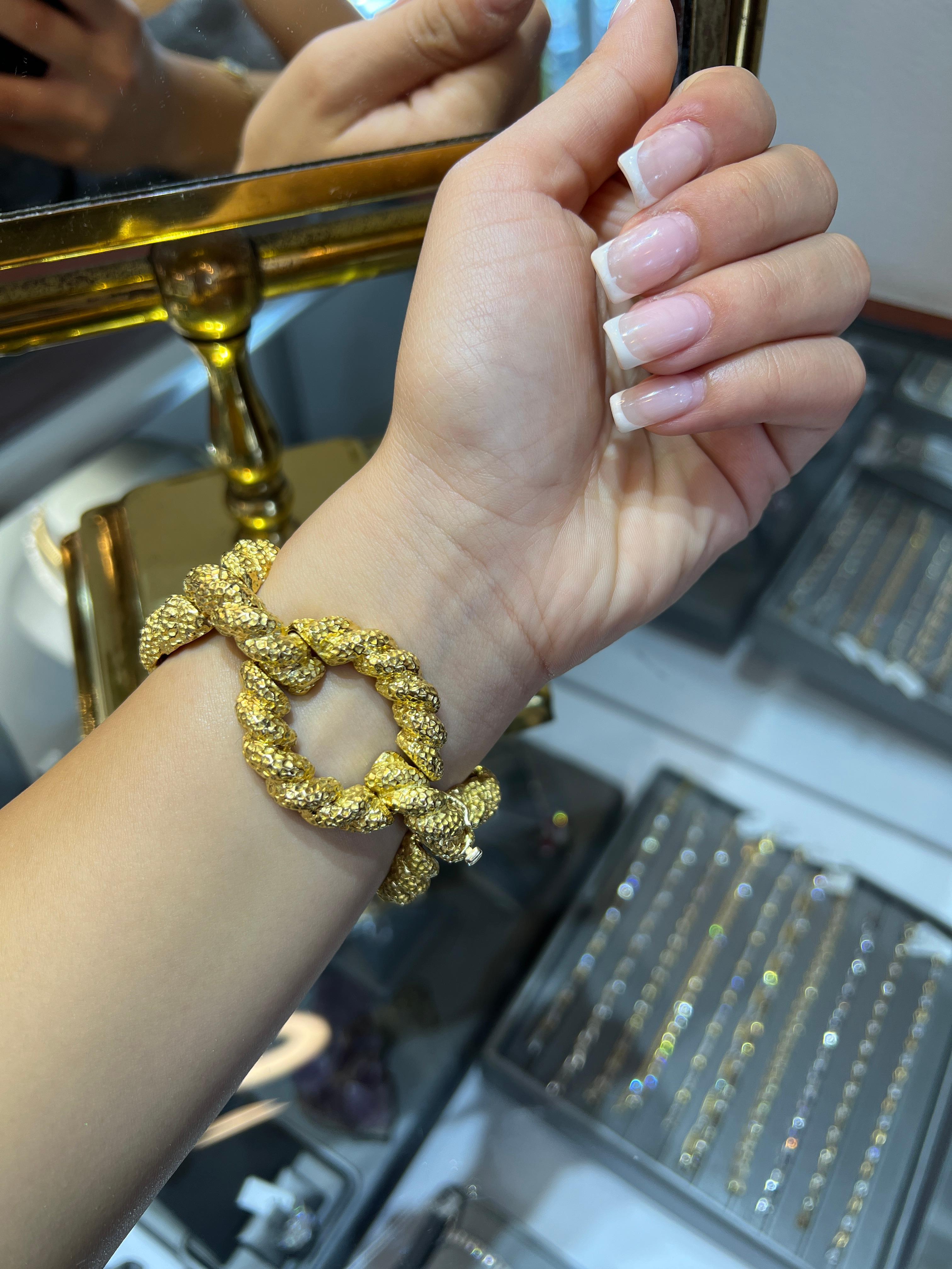 Questo braccialetto vintage in oro massiccio 18 carati è l'emblema degli anni '60 francesi, un pezzo audace e sorprendente. Realizzato intorno al 1960, pesa ben 91 grammi ed è composto da maglie d'oro martellate di grandi dimensioni, che riflettono