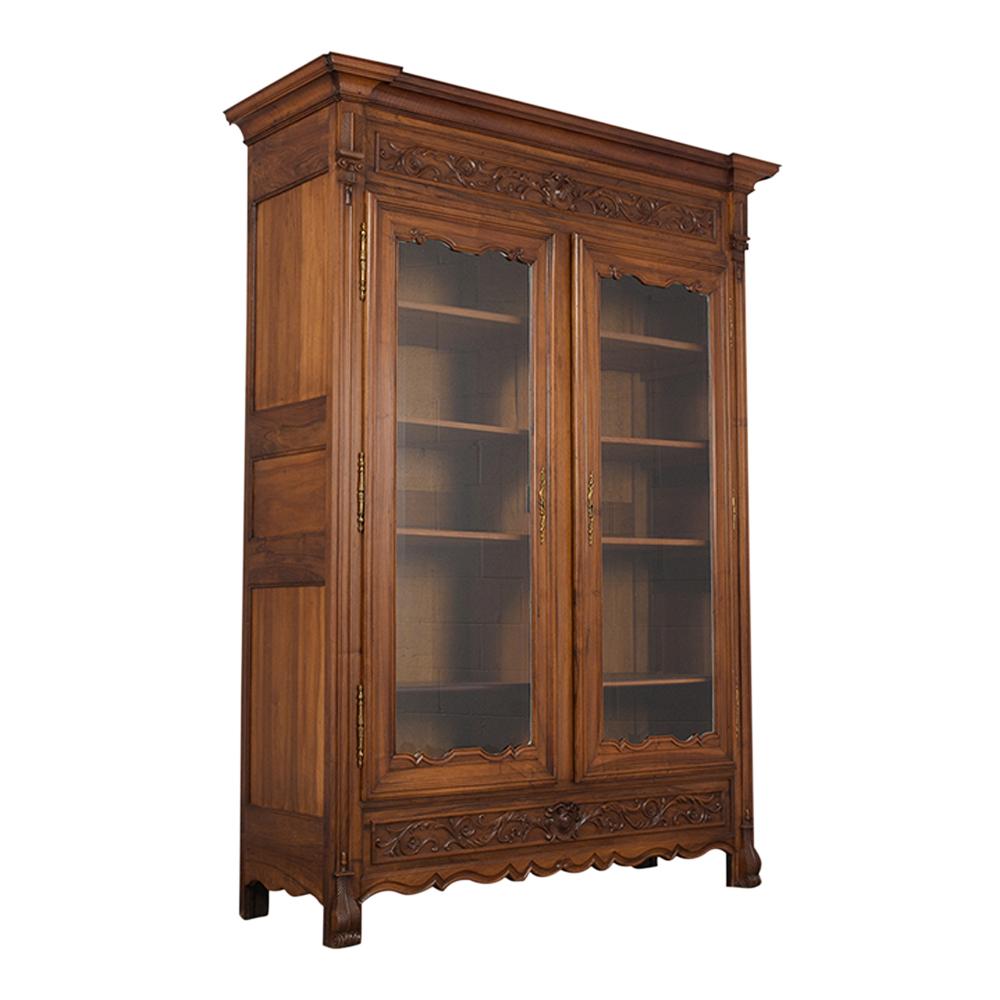 This French 19th Century Spanish-Style Bookcase is made of solid walnut wood with original walnut finish and has been completely restored. The bookcase has been waxed and polished developing a beautiful patina. It also features hand-carved moldings
