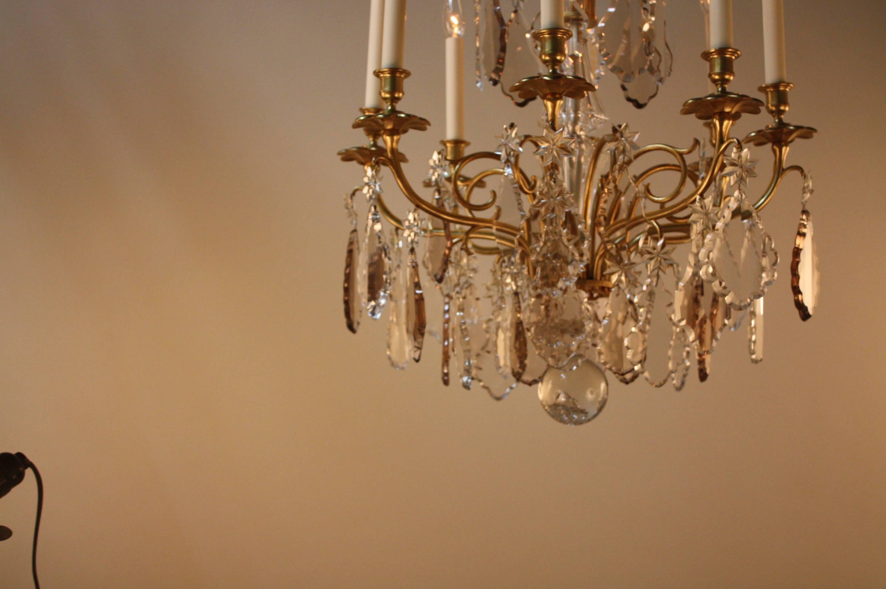 Elegant 1930s eight-light bronze chandelier with large sparkling hand polished multi-color crystal prisms.
Measurement: 22