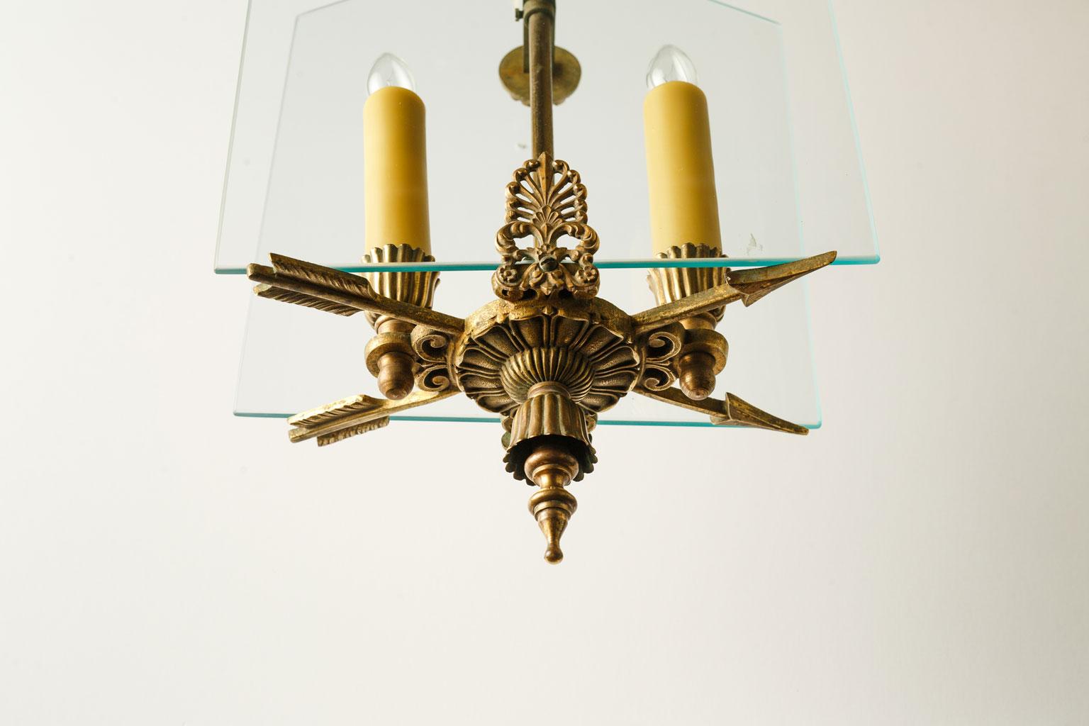 French Classic brass and glass chandelier. Two candelabra-size lights partially enclosed or sandwiched betwen two plates of clear glass. A classic light with a modern feel. Newly wired for use within the USA. Includes chain and a canopy. The light