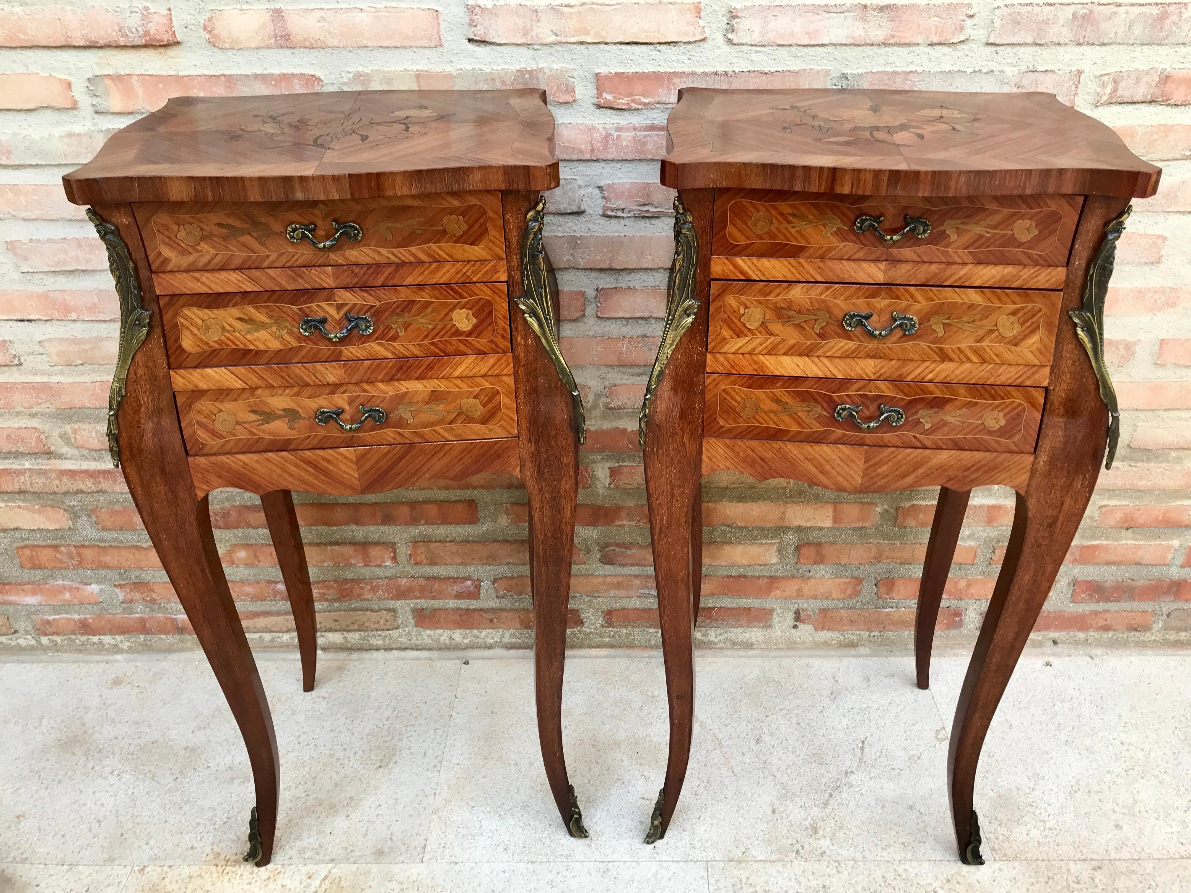 Pair of French Louis XV style nightstands with gorgeous floral and herringbone marquetry, herringbone inlaid box, gilt bronze mounts, three drawers with original bronze pulls and elegant legs with French kickstands and bronze trim.

Design Period