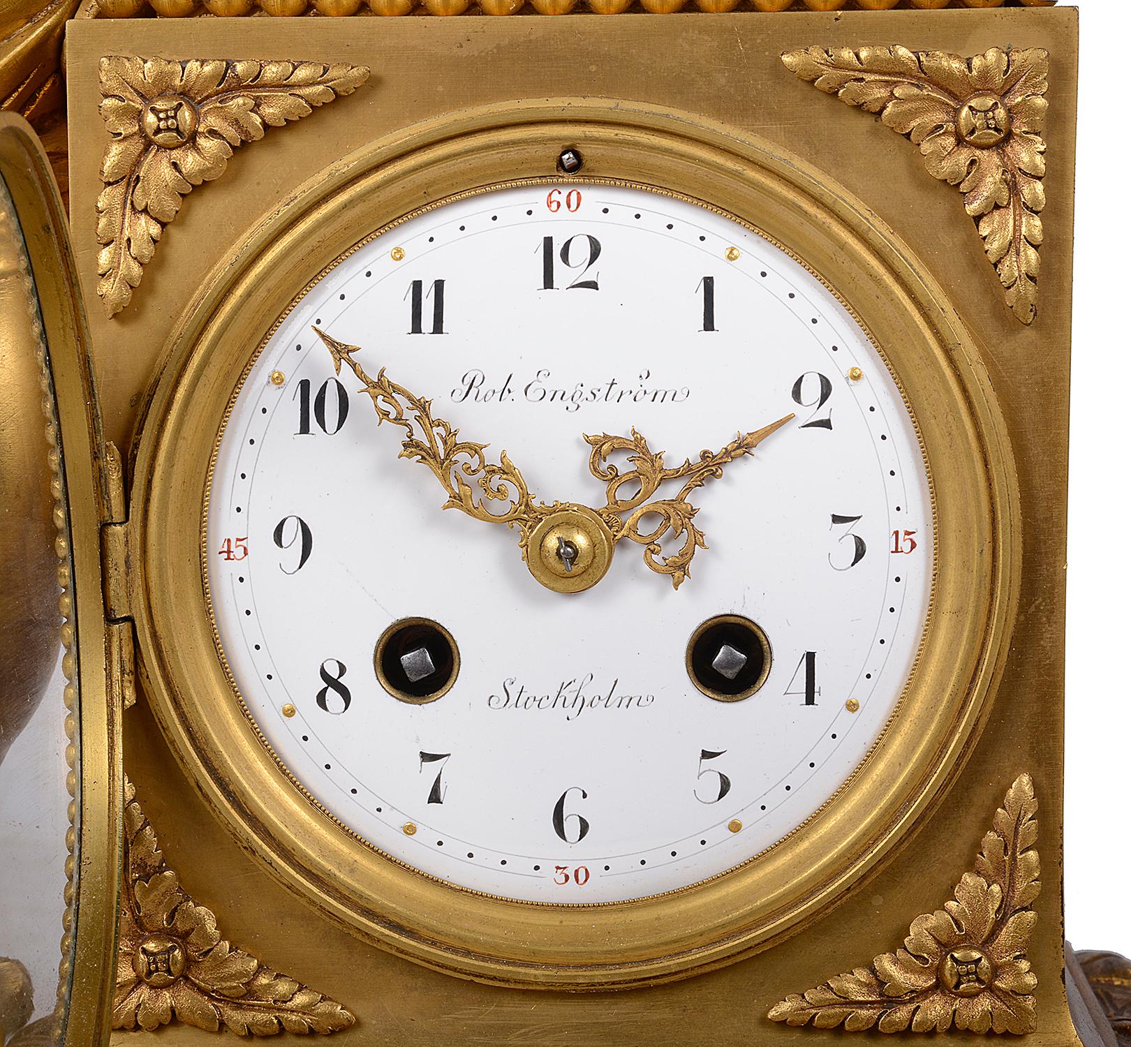 An enchanting classical Louis XVI style gilded ormolu and marble mantel clock, having a standing cherub holding a Cockerel above a white enamel clock face, retails name; Rob. Engstrome, Stockholm. The eight day duration clock strikes on the hour and