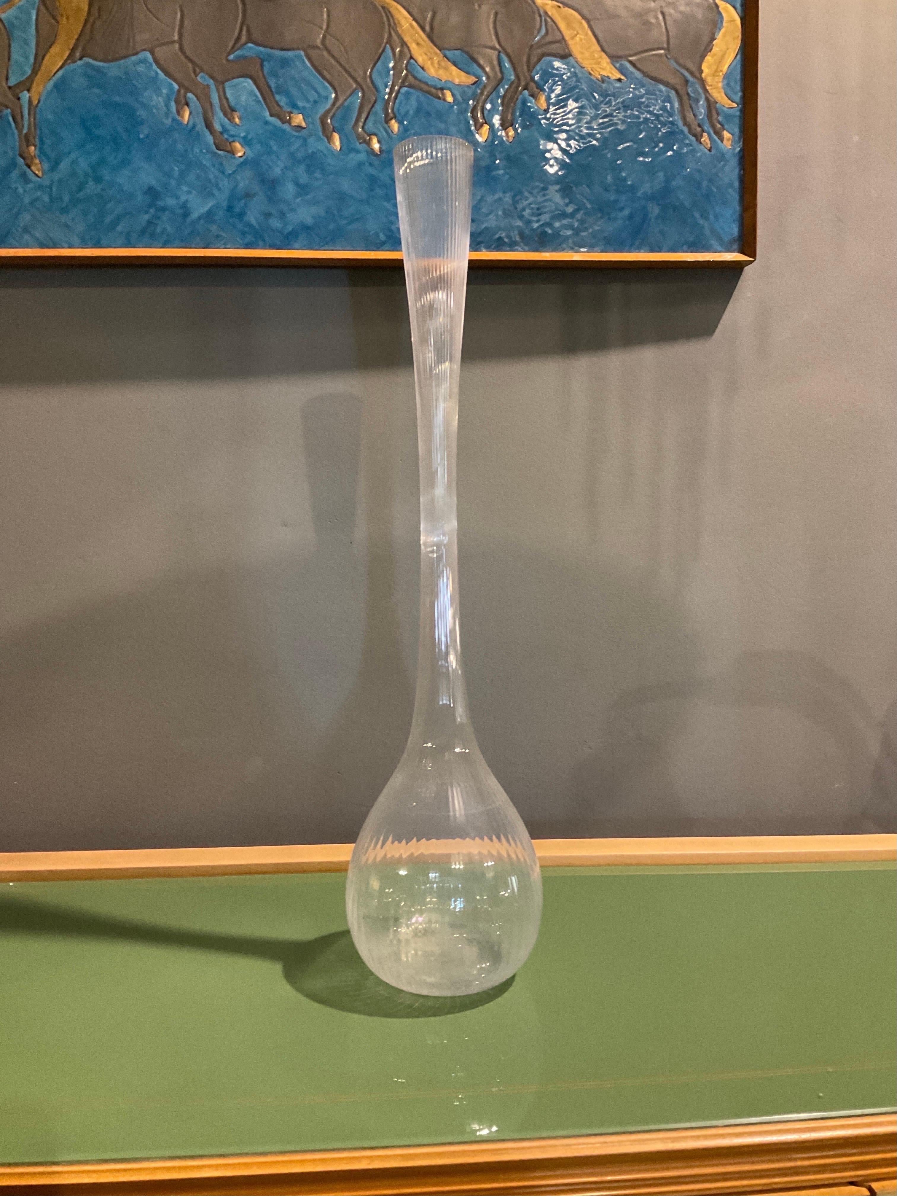 This elegant glass vase was crafted by the renowned French manufacturer Daum in the 1970s. Its sinuous, slender form is a perfect example of the style, and the clear glass accentuates its graceful curves. The vase's simple yet striking design makes