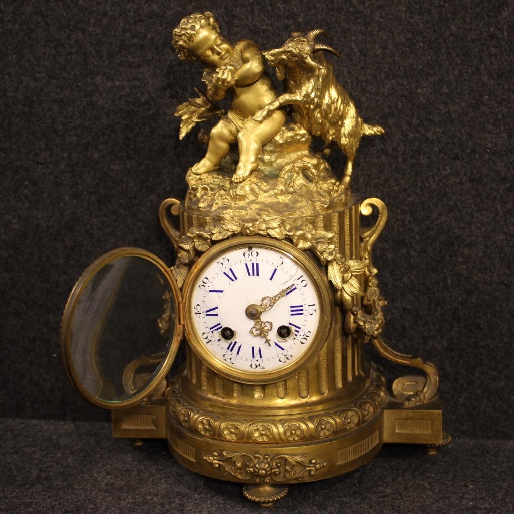 French clock from the late 19th century. Object in bronze finely chiseled is gold adorned with sculpture with putto and kid. Clock with ceramic dial enameled with some small chips and signs of restoration (see photos) and brass hands gold is