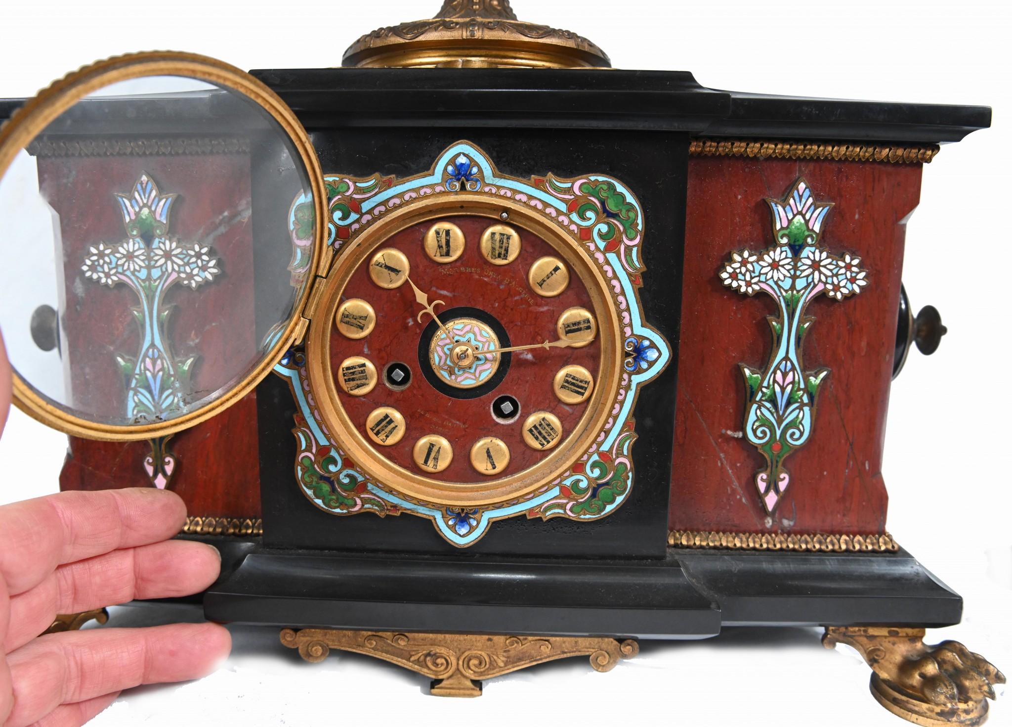 You are viewing a phenomenal French Aesthetic Movement clock and garniture set
L'interaction entre le cloisonné, le marbre et le champlevé est d'une qualité artisanale étonnante.
Les luminaires en bronze doré sont également d'origine et comportent