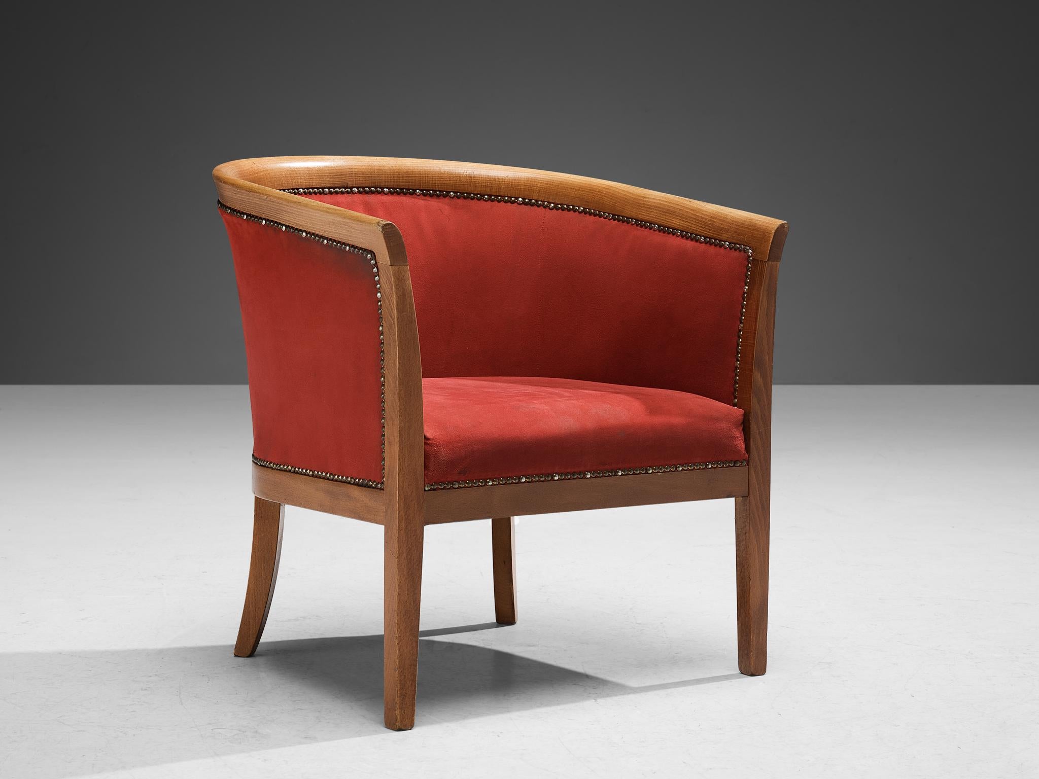Club chair, leatherette, beech, brass, France, 1940s.

This classically sculpted armchair features a seating that is designed as a shell, which embraces the sitter wonderfully. The curvaceous lines of the frame are further emphasized by the brass