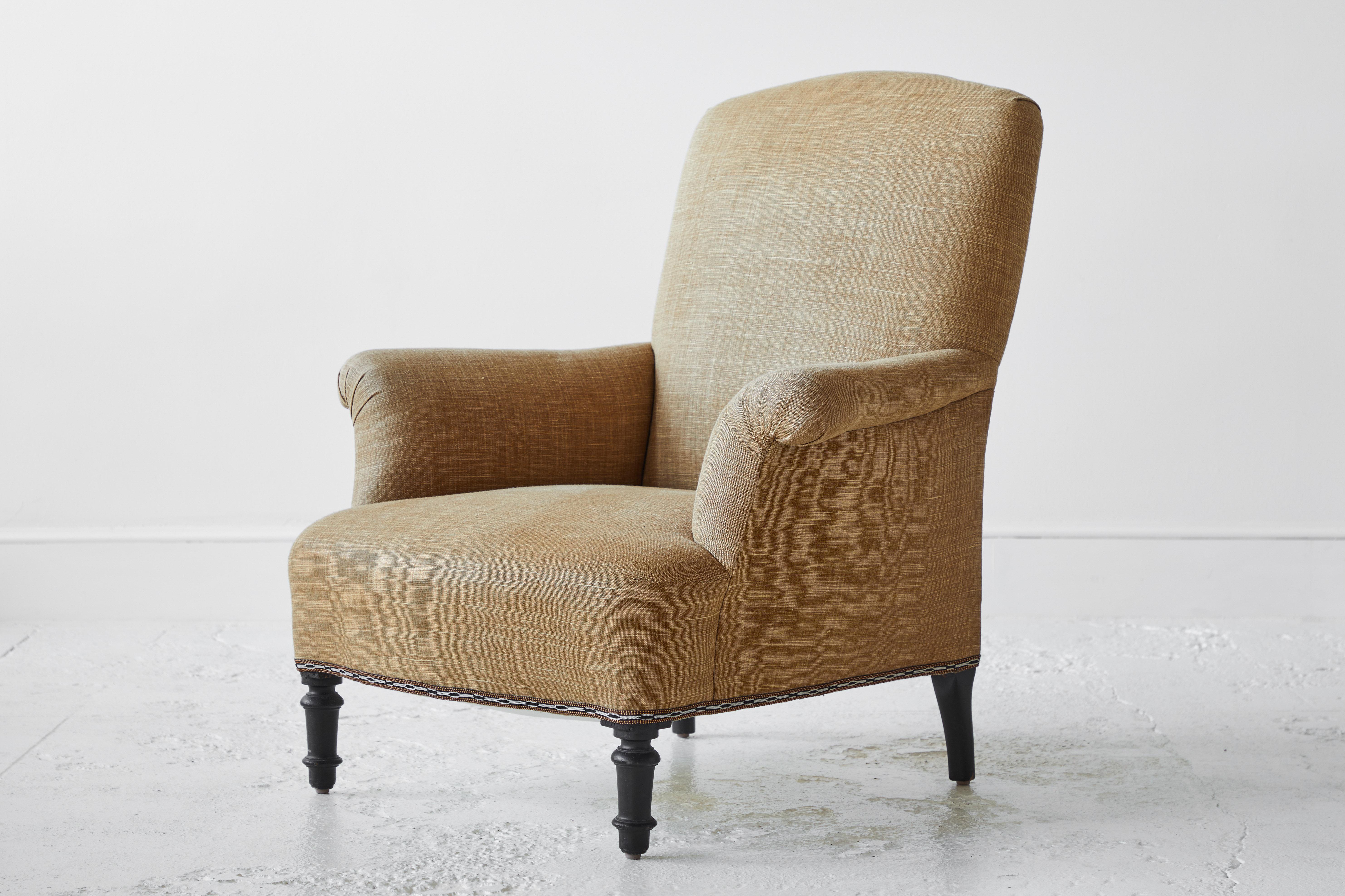 French Club Chair upholstered in a mustard colored Linen, the chair has a sweet vintage trim by Susan Deliss. The legs are original and the finish has not been altered. 
