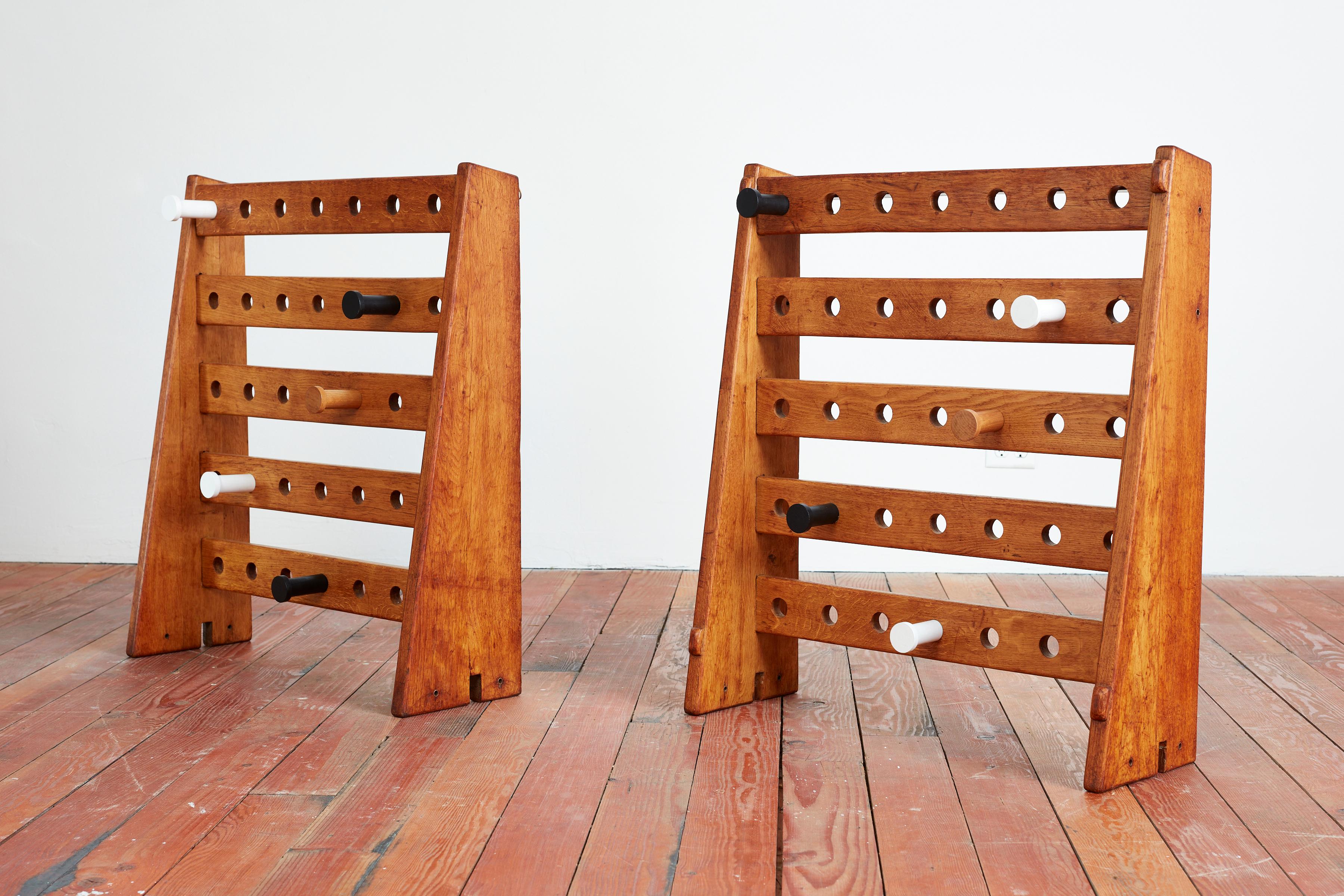 Unique French coat hangers with angular oak plank legs with wonderful patina and giant white / black circular hooks. 
Racks are free standing or can also be hung on a wall 
Most likely from a ski lodge or French School 
Playful design and