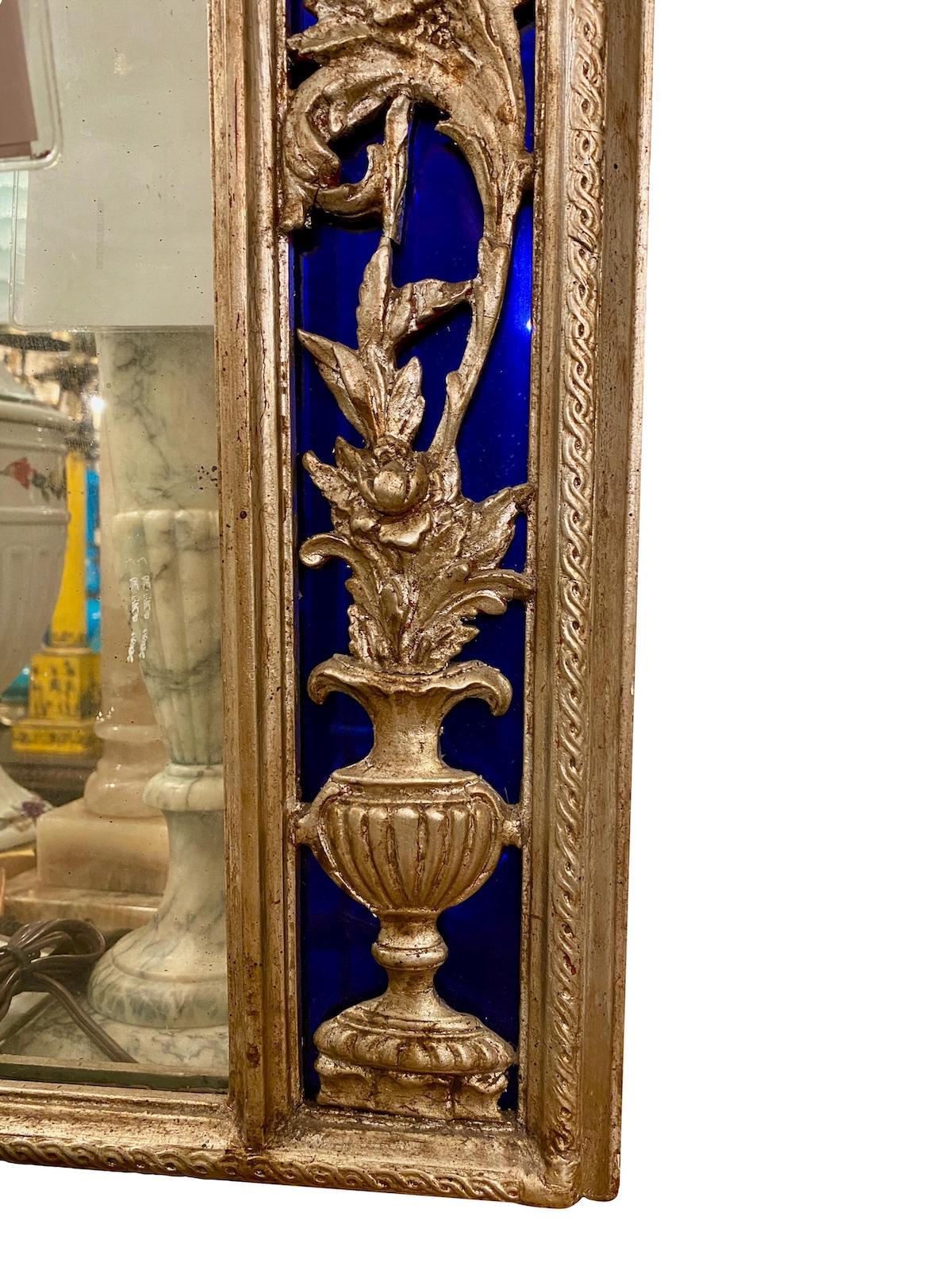 A circa 1930s French neoclassic style silver plated mirror with foliage detail and cobalt blue mirror frame.

Measurements: 
Height 43.5
