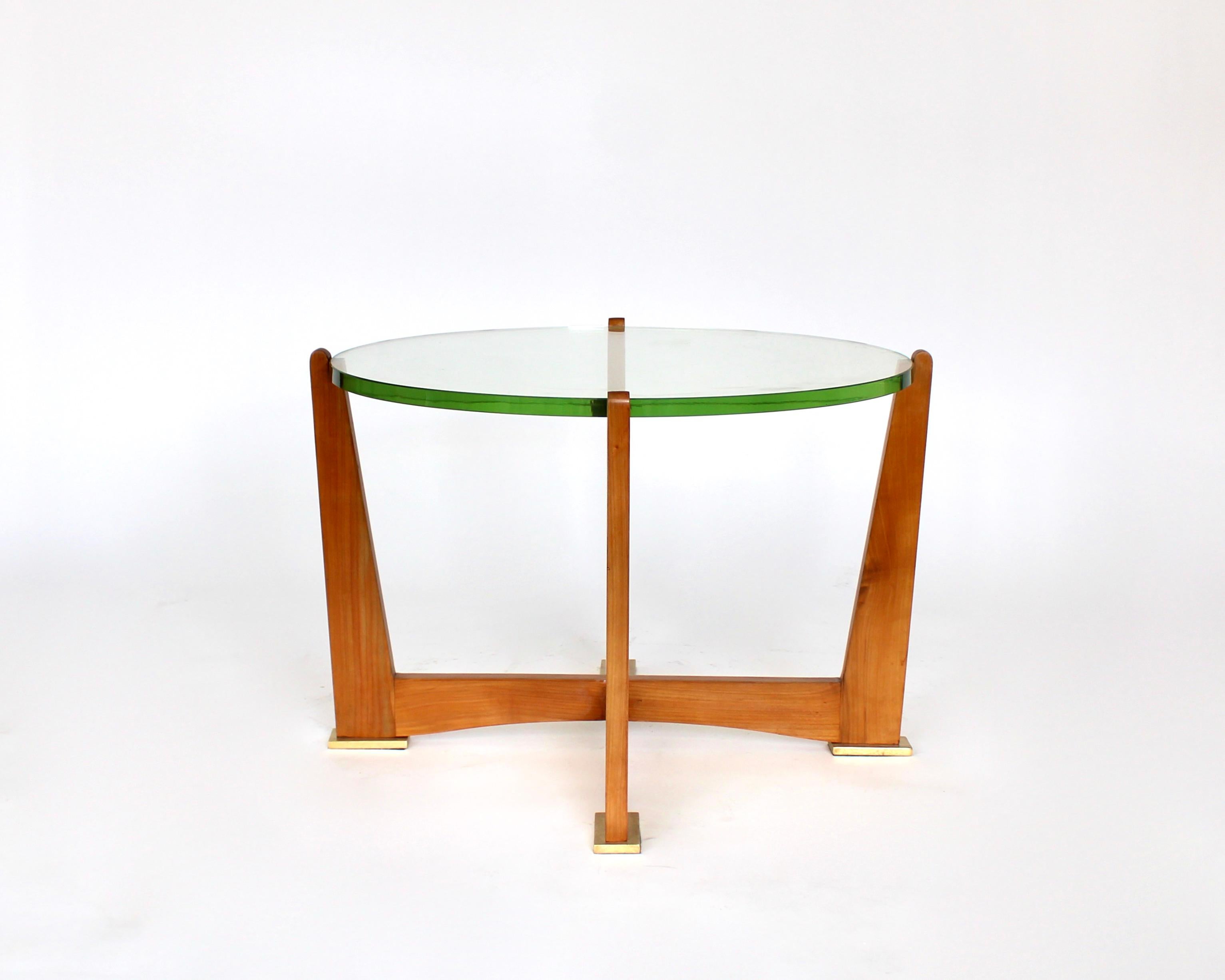 This coffee or side table is attributed to Maxime Old, one of the great French Art Deco and into the 70's designers. 
Round French St Gobain thick original glass on a Cherry wood frame composed of four gently flaring outwardmtapering arms that