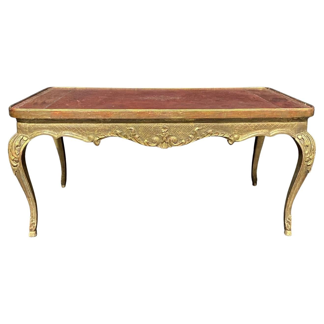 Elegant French Louis XV marble top gold gilt painted coffee table with exquisite embossed leather top. The graceful contours of the style have been presented on all four sides with a richly contoured apron all around carved with exquisitely wrought