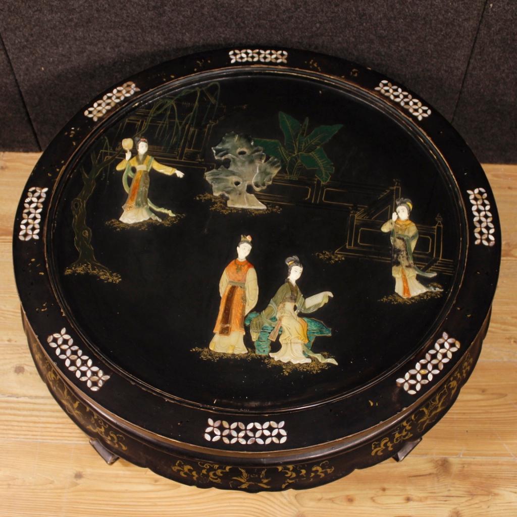 French table of the 20th century. Furniture in carved wood, lacquered and painted a
chinoiserie of beautiful decoration. Round coffee table with upper top decorated with relief elements in soapstone and protective glass, of discreet size and